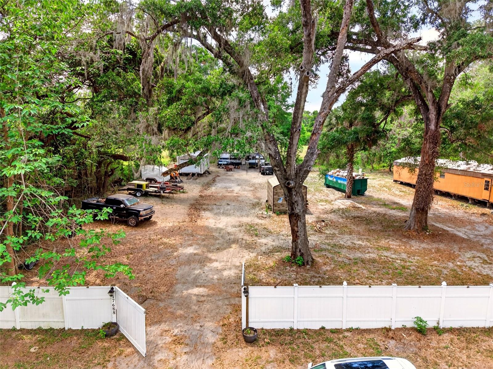 Located in a quiet and convenient area of Citra with easy access to 441 and just a short drive to Ocala, this unique .69-acre property is packed with opportunity, flexibility, and future potential. With no HOA restrictions and a privacy fence spanning the front of the property featuring two gated entrances, this property offers both privacy and functionality from the moment you arrive. The existing 2-bedroom, 2-bath manufactured home has already been completely gutted, creating the perfect blank slate for an investor, builder, or buyer ready to bring their vision to life and give the property a fresh new beginning. Whether you’re looking to renovate, expand, or create a long-term investment, the groundwork has already been started. One of the standout features of the property is the presence of two separate wells and septic systems, opening the door for the potential addition of another homesite or expanded utility options. One well has already been updated with a 2025 pump and bladder tank, providing added peace of mind and reliability moving forward. Adding even more value is the included 2022 32-foot Prowler camper with water and septic already connected—offering a comfortable place to stay while renovations are completed or an excellent setup for flexible living arrangements. The property also includes a 2020 insulated 12x30 shed ideal for storage, workshop space, or hobby use, along with an additional centrally located 10x15 shed featuring a buried water line for convenient washer and dryer hookup. With multiple utility features already in place, flexible use potential, and a peaceful location close to town, this property presents an outstanding opportunity to create your dream compound, investment property, or private homestead.