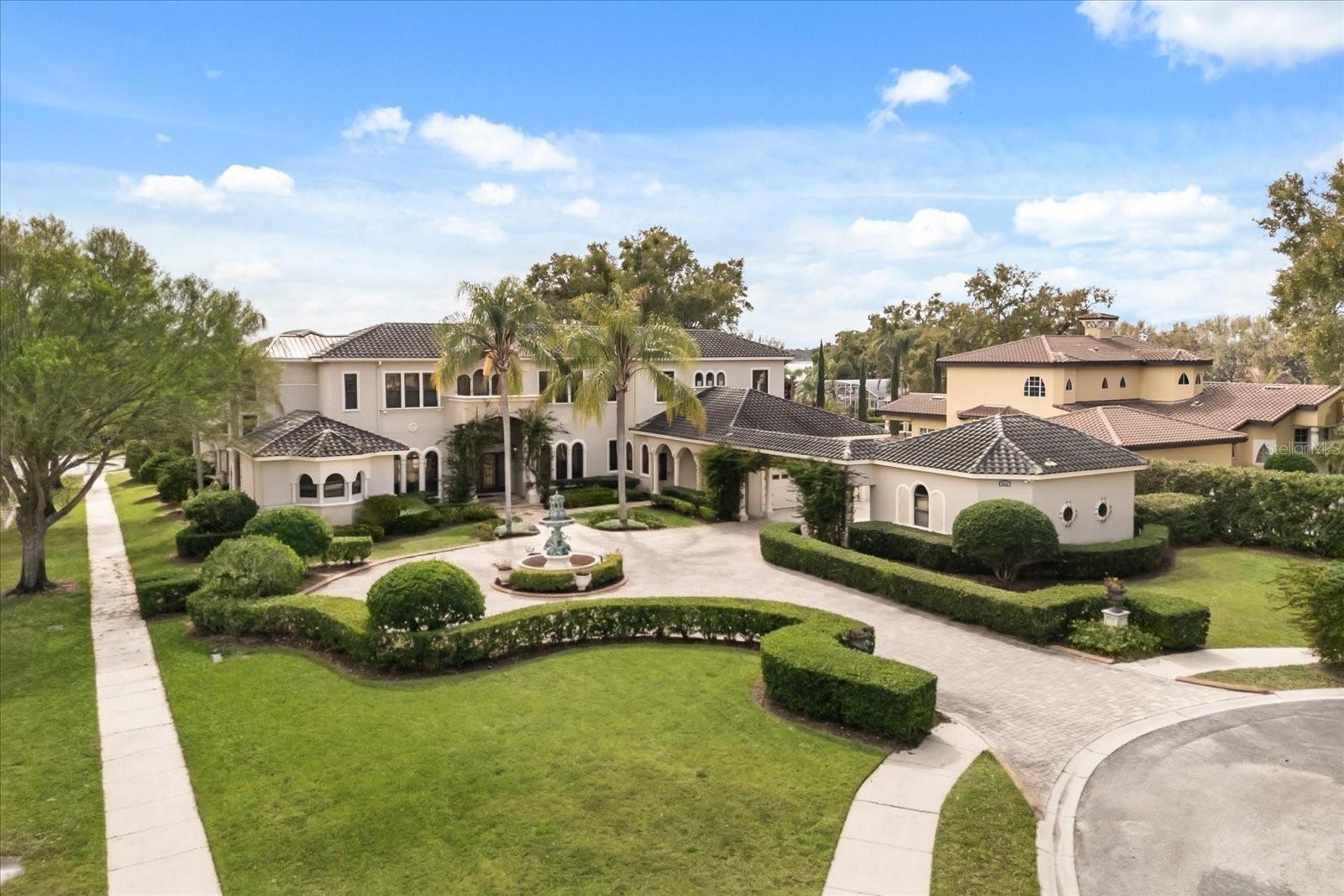 Welcome to an extraordinary 8700+ SQ FT estate located within the GATED COMMUNITY of Marbella in Windemere. This estate offers 40 feet of frontage on Lake Down complete with a private dock and boat lift. Access to Lake Butler & Situated on 2.17 acres, this custom-built pool home blends timeless architecture with superior craftsmanship and premium finishings throughout — including stone, wood, iron, granite, and travertine.

A grand entrance featuring custom wrought iron doors opens to a dramatic two-story foyer framed by a stunning wall of windows overlooking the backyard oasis. Elegant formal living and dining spaces are complemented by an oversized wet bar, perfect for entertaining.

The gourmet kitchen is designed for both beauty and performance, showcasing custom cabinetry, a six-burner gas cooktop, dual side-by-side refrigerator and adjacent butler's pantry. It seamlessly flows into the impressive great room with cathedral ceilings, exposed beam millwork, fireplace, and expansive glass doors leading outdoors.

The luxurious primary suite features volume ceilings with exposed beams, a private sitting area, walk-in closet, and a newly renovated spa-inspired bath with soaking tub and multi-jet walk-in shower.

This estate offers four additional en-suite bedrooms, two dedicated offices, media/movie room, craft room, a detached gym and a three-car garage — providing exceptional space and flexibility. 

Designed for true indoor-outdoor living, the backyard retreat includes a resort-style pool with rock waterfall and slide, spa, pool house, summer kitchen, volleyball court, and lush garden setting — ideal for entertaining or peaceful relaxation.

A rare opportunity to own a private lakefront sanctuary in one of the area’s most desirable gated communities.