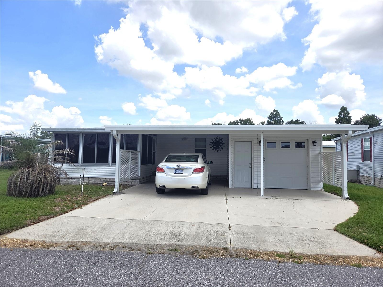 What a beauty this one is! All updated and waiting for you! Own your own land! Resort style living for an affordable price! Run your own life as
this is a community owned by the residents and we make the decisions (I live here!) The HOA includes everything except your electric bill and
lawn mowing! This 1990 Double Wide is 1040sf with 2 beds/2 baths, includes a Laundry Room, a front Lanai, plus a covered patio out back.  Kitchen with new SS appliances, Luxury Vinyl floors throug out, Large Pantry for the kitchen, A BRAND NEW AC, and a membrane roof!  A spacious carport is complemented with a shed that is also a golf cart garage with automatic opener. All windows are tilt-in dual pane. Painted walls.  NO GREY PIPE. Golf cart is staying!  Shed for all your crafts or tools. Enjoy 18 holes of golf for just $5 green fees in this Gated, Golf Community, located just outside of the city, and approx. 1.25 hrs. from either coast. Great access to Disney, Legoland, and BOK Tower, just to name a few local attractions. In this very friendly, resident-owned community, you can be as active or inactive as you choose! Gatherings at the private Pub or the Community Room, fishing & boating on Lake Henry (dock within the community), gardening, tennis, golf, shuffleboard, pickle ball, horseshoes, swimming in the heated pool, enjoy the hot tub or the 24/7 workout room! Contact this community's website for documents, including Rules/Regs, Application, Financial, and Bylaws. HOA INCLUDES A DVR PLUS 2 HD CABLE BOXES AND INTERNET! (Minimum age in this 55+ community is 50 years old)