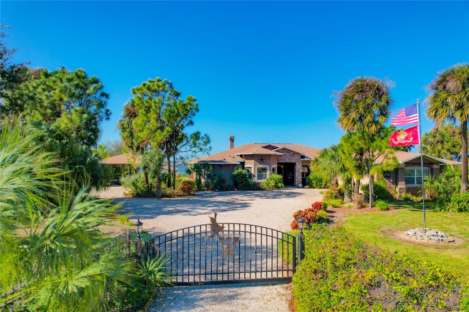 Welcome to this beautifully maintained 3-bedroom, 3.5-bathroom, 3 car garage custom-built one-story home located in the desirable community of Lost River Preserve. The property is nestled on 2 acres of lake frontage and has a completely fenced-in yard with an electric gate on a cul-de-sac that is surrounded by 900 acres of a nature preserve. This home features an in-ground heated pool with screened enclosure overlooking the private lake, a detached pole barn that can fit 4 vehicles underneath the roof, and a wet bar in the living room perfect for entertaining. The spacious open floor plan includes split bedrooms, dedicated office/den, original hard wood floors, crown molding throughout, formal dining room, interior laundry room, and a family room with a wood burning fireplace. The primary bedroom offers an en-suite bathroom with dual sinks, soaking tub, electric fireplace, two walk-in closets, tray ceilings and a 2nd cabana bathroom that leads out to the pool area. Another great area to entertain is the fully equipped kitchen which offers a breakfast bar, eat-in kitchen, ample solid wood cabinetry, granite countertops, large pantry closet, and new appliances including two new refrigerators (one in wet bar) and two new built in ovens. The crown jewel of the home is the outdoor oasis overlooking the lake with incredible views including a firepit, garden area, and dock. Other highlights include: two new Goodman HVAC systems, new Wi-Fi smart water heater, remodeled fireplace mantle in living room with built in storage cabinets, and a recently sprayed roof w/Roof Maxx that includes a 5-year transferrable warranty. Lost River Preserve is a community with only 81 homesites on 900 acres including 5 fish-stocked lakes, nature trails, and picnic areas while showcasing luxurious executive style properties on oversized lots. This community has a low HOA, No CDD, and the home is elevated in coveted flood zone X. In addition to the private lake, Cockroach Bay State Preserve is 5 minutes away which provides access to the Tampa Bay.  Quite simply there's not many one story homes on 2 acres of land overlooking a lake in a non flood zone.   The central location offers quick access to Apollo Beach 5 minutes away, Downtown Tampa 35 min. away, downtown St. Petersburg 35 min. away, and downtown Sarasota 45 min. away. Don’t miss your chance to make this gorgeous property your own. Schedule your private showing today of this stunning custom-built home that is sure to impress!