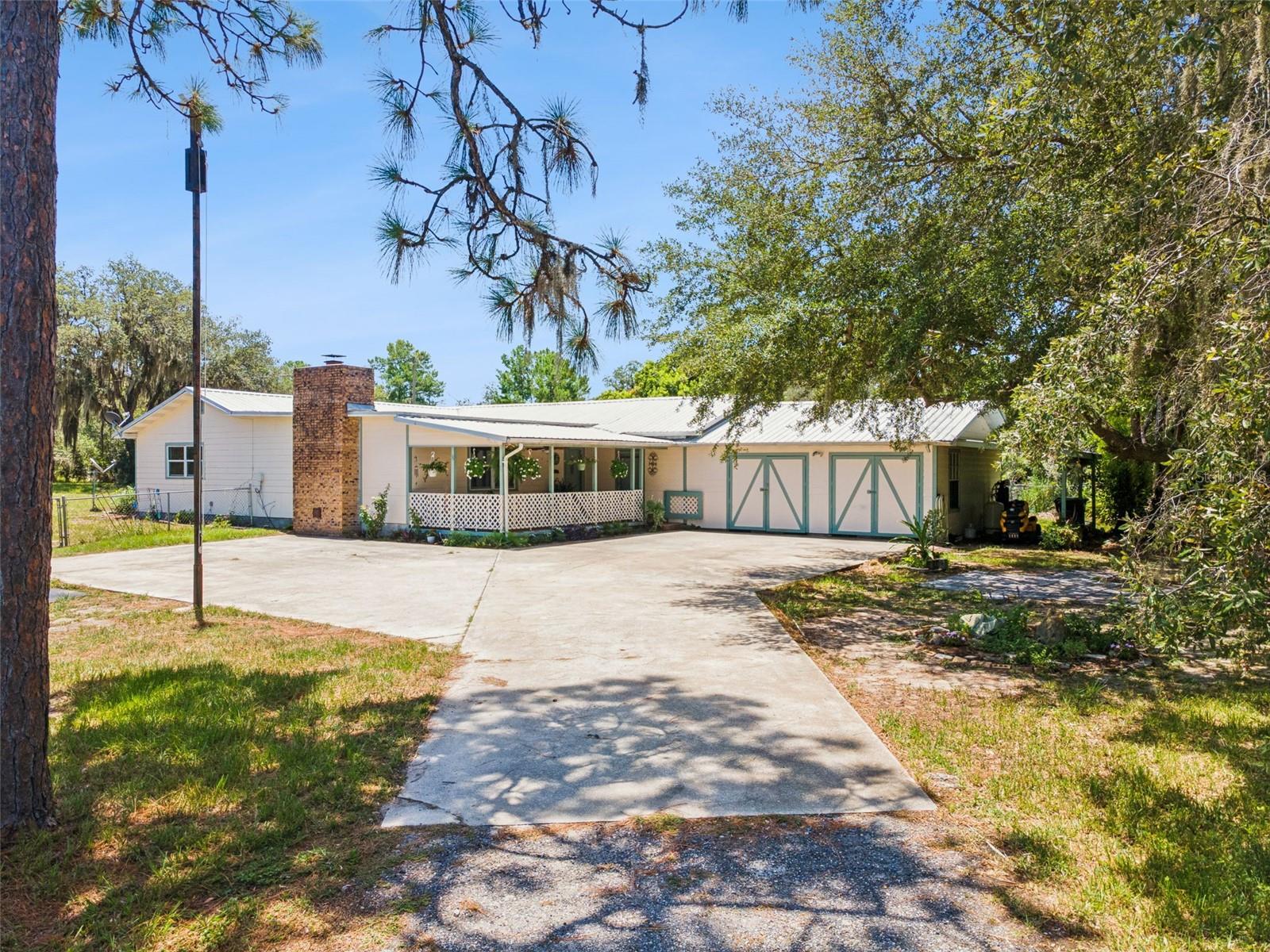 Looking for a 5-Acre Country Retreat? Don't Miss This One!
Bring the horses, bring the toys, and enjoy the peaceful country lifestyle offered by this beautiful 5-acre property!
As you enter through the gated entrance, you'll be welcomed by a scenic drive down to the home surrounded by nature and a picturesque pond. A good sized concrete parking area leads to the home, where a spacious covered front porch with a ceiling fan overlooks magnificent oak trees, creating the perfect place to relax and unwind.
Inside, the home features a welcoming split-bedroom floor plan. The spacious living room offers a cozy wood-burning fireplace, while the dining area flows seamlessly into the open farmhouse-style kitchen. The kitchen is designed for both everyday living and entertaining, featuring a large center island, abundant cabinetry and storage, stainless steel appliances, a pantry, and a utility storage closet.
An open den/office space sits between the living room and bedrooms, providing a flexible area for working from home or a hobby space. The oversized laundry room includes plenty of cabinets, a utility sink, and extra storage. Also leads to the  mud room.
The primary suite offers two walk-in closets and an ensuite bathroom with a walk-in shower, vanity, and an additional large  closet. The other two bedrooms share the second bathroom with a tub/shower combo.
Step out the kitchen to the covered and screened back porch with tile flooring and a ceiling fan—the perfect place to enjoy beautiful Florida evenings.
Additional features include:
Whole-house water filtration system with salt system and a water softener.
Oversized two-car garage.
Covered carport ideal for storing ATVs, boats, trailers, or equipment.
The fully fenced property is ready for your animals, with a combination of chain-link, wire, and wood-board fencing, along with temporary hot-wire fencing for horse pastures. One pasture includes a horse shelter, while several pastures are shaded by mature oak and pine trees.
Nature lovers will appreciate the abundance of wildlife, with deer frequently visiting the property. The land also features a variety of fruit trees, including orange, lemon, pear, peach, pecan, mulberry, guava, and avocado.
A beautiful oak tree at the front of the property has a paved sitting area beneath its canopy, creating a peaceful shaded retreat. There's also a large shed with chicken coops on three sides (ready for a little TLC) and a dedicated garden area for growing your own vegetables, herbs, or flowers.
Outdoor recreation is just minutes away with Lake Wales Ridge State Forest nearby, offering miles of horseback riding trails during the non-hunting season.
Despite the private country setting, you're only about 15 minutes from downtown Lake Wales, with convenient access to Walmart, Lowe's, feed stores, restaurants, shopping, and everyday amenities.
If you've been searching for a private country retreat with room for horses, livestock, gardening, recreation, and peaceful Florida living, this property is a must-see!