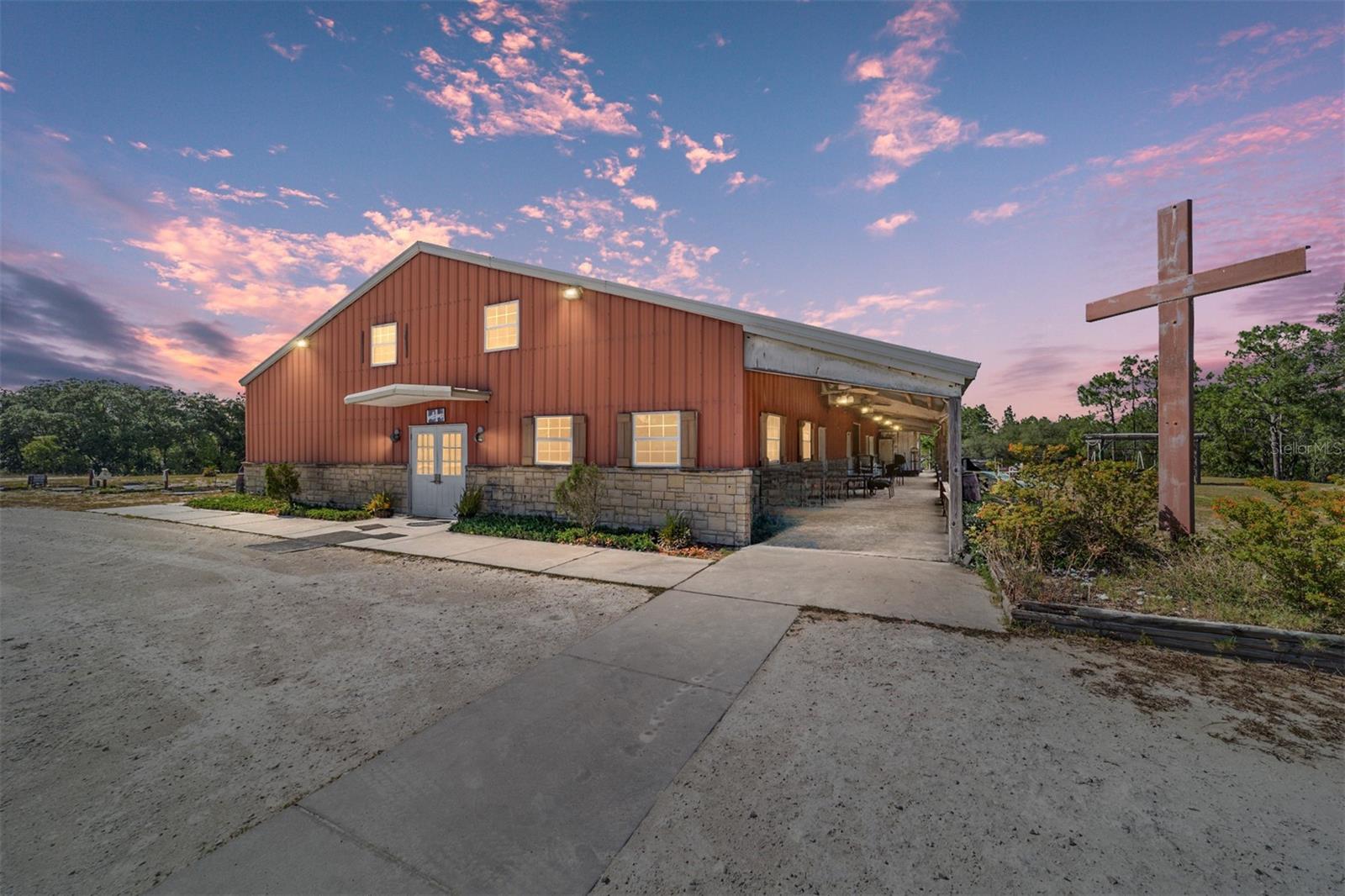 UNIQUE 20 ACRE PROPERTY – MULTI-USE SPACE + HOME – SELLER READY TO NEGOTIATE! Set on 20 beautiful acres, this rare and versatile property is ready for its next chapter! With over 5,000 sq. ft. of flexible space under one roof, the possibilities are endless—create a one-of-a-kind residence, establish a custom farm, open a retreat center, or bring your congregation to the country. The seller is eager to make a deal and will review all serious offers, so now is the time to act.

MAIN BUILDING HIGHLIGHTS

    Downstairs: A massive 40’ x 50’ open hall with soaring 18’ ceilings—ideal for events, gatherings, or creative use. A full commercial kitchen with a pass-through window serves both indoor and outdoor spaces. Six flexible classrooms (~200 sq. ft. each), separate men’s and women’s restrooms, additional wheelchair-accessible facilities, a 400 sq. ft. storage room, and six commercial A/C units for comfort year-round.

    Upstairs: Two office spaces, a sound booth overlooking the main hall, multiple storage rooms, and a laundry room with ½ bath—perfect for administrative needs or living quarters.

OUTDOOR & EXTRA FEATURES
Enjoy a full-length covered porch, a 2 acre parking area, remnants of a putt-putt course and shuffleboard court, and two charming log buildings ready for restoration. A 1,150 sq. ft., 3BR/2BA manufactured home is included for on-site living or rental income.

With limitless potential and a motivated seller, this property won’t last—bring your vision and your offer today!
