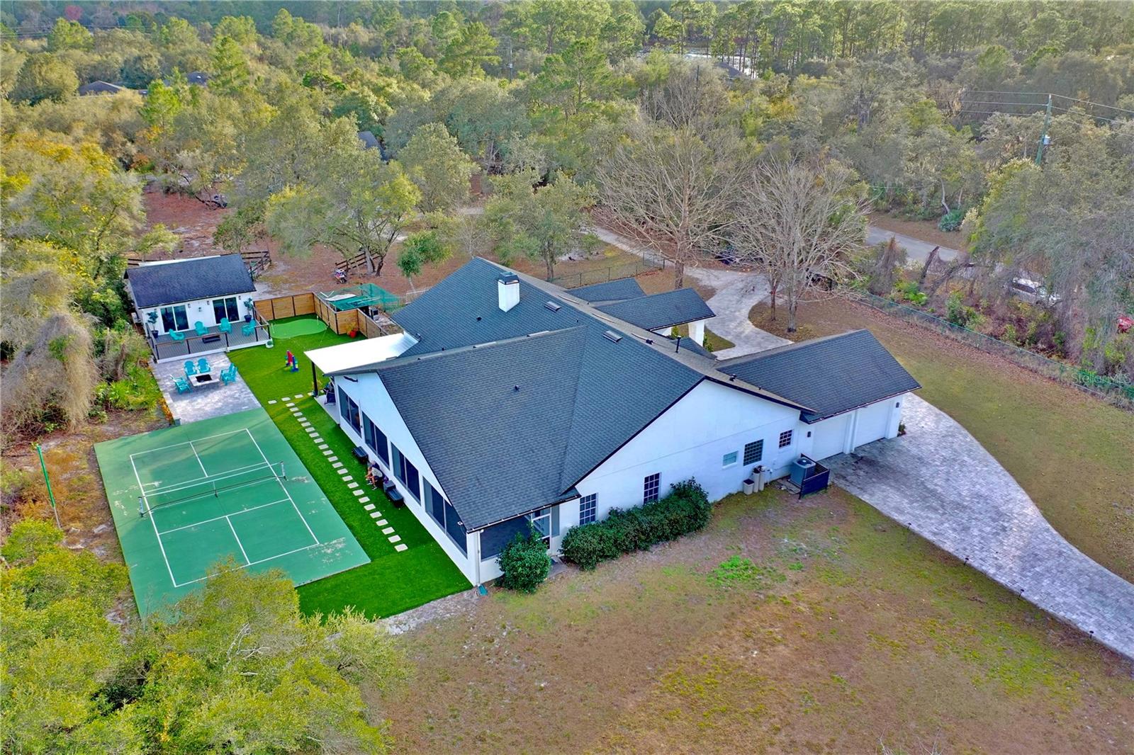 Beautiful WATERFRONT COUNTRY ESTATE in the exclusive EQUESTRIAN community of SEMINOLE WOODS! Featuring a separate GUEST HOUSE, full-size PICKLEBALL COURT, and resort-style amenities! Starting with the newly built 1,600 sq. ft. GUEST HOUSE which offers 2 bedrooms, 1.5 baths, a spacious kitchen, and its own garage, ideal for guests or multi-generational living.

The NEWLY DESIGNED main residence features 4 generously sized bedrooms, 3 beautiful bathrooms, an impressive FIREPLACE, and a breathtaking CHEF'S KITCHEN with a 12-foot island, 8-burner gas range, and ample storage, perfect for entertaining. The primary suite includes a custom walk-in closet and an OFFICE/SOUNDPROOF STUDIO, easily convertible to a second walk-in closet.

The RESORT-STYLE BACKYARD offers a screened COVERED PORCH, PICKLEBALL COURT, custom LANAI with OUTDOOR KITCHEN and BAR, FIRE PIT, MINI GOLF AREA, entertainment space, and high-quality artificial turf for year-round beauty. Between the main home and guest house is a private enclosed GYM with GARAGE ideal for a man cave. Also features amazing WATER VIEWS and a beautifully PAVED circular driveway with TWO ELECTRIC GATES, plus much more! The equestrian community features miles of SCENIC HORSE TRAILS, HIKING, is GUARD GATED and has an amazing PARK perfect for parties, family activities, BOATING, JET SKIING or just sitting on the sandy BEACH area to soak up the sun.  The park area also features a PRIVATE SKI LAKE with a BOAT RAMP, DOCK, playground area, basketball court, bathrooms and a PARTY PAVILLION perfect for your special gatherings. Top-rated Seminole County schools and a convenient location just minutes from SR 417, shopping, UCF, Advent ER, St. Johns River boat ramps, and New Smyrna Beach!  This home is the perfect blend of country style living, luxury and convenience! Schedule your private showing today!