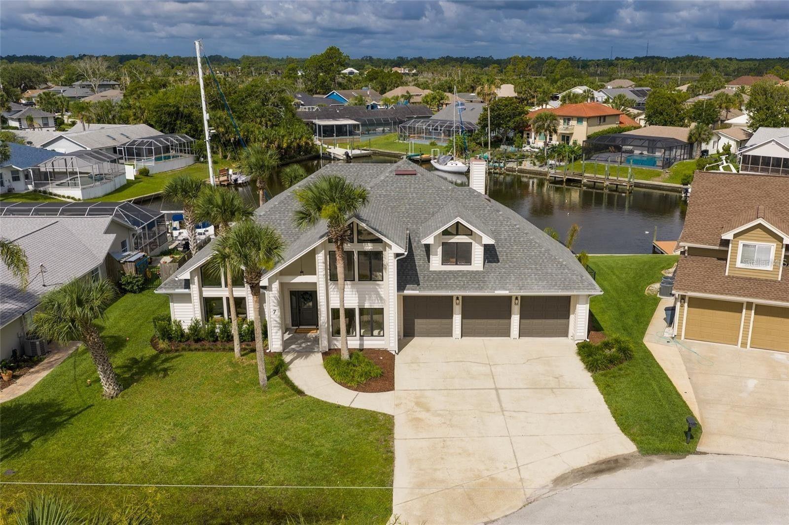 Completely renovated and move-in ready, this canal-front residence offers 4 bedrooms, 3 bathrooms, an upstairs bonus room, and 3,202 square feet of thoughtfully designed living space. Located in the highly sought-after Sailboat Country of Palm Coast, this home showcases timeless coastal architecture with soaring ceilings, expansive windows, and abundant natural light, seamlessly blending modern elegance with comfortable waterfront living. The beautifully redesigned chef’s kitchen features custom cabinetry, quartz countertops, premium stainless steel appliances, a spacious center island, and extensive storage, opening effortlessly to multiple living and dining areas ideal for entertaining. The inviting family room is anchored by a stunning stone fireplace with custom built-ins, while the downstairs Florida room provides additional flexible living space overlooking the water. The spacious primary suite offers private balcony access and a spa-inspired bath complete with dual vanities, soaking tub, and walk-in shower. Upstairs, the bonus room creates the perfect space for a media room, office, or playroom. Step outside to enjoy the private pool and expansive paver patio, perfectly positioned along the canal with peaceful water views and room to relax or entertain year-round. Additional highlights include luxury vinyl flooring throughout, designer lighting, upgraded bathrooms, custom millwork, and a 3-car garage. Ideally located in Palm Coast with convenient access to boating, golf, shopping, dining, and the beach, this beautifully renovated waterfront home delivers the ultimate Florida lifestyle.