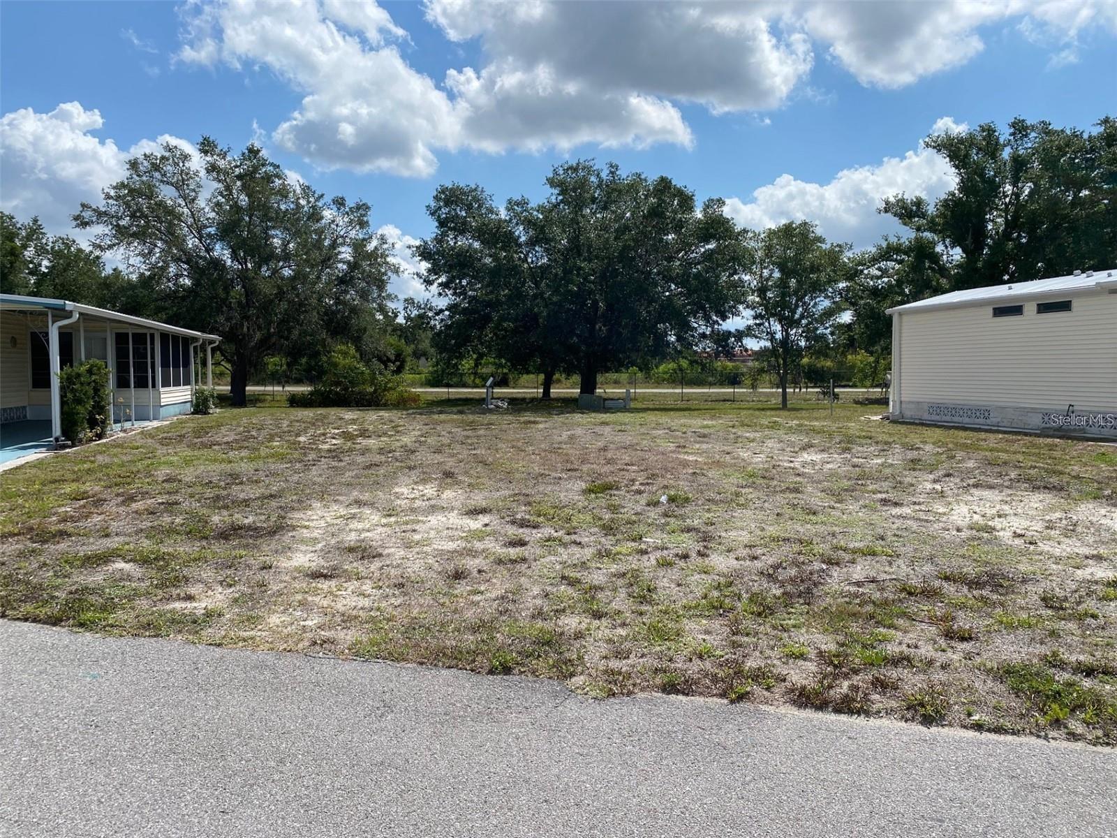 The best lot in the gated community of Holiday Park is available. No neighbors in your very Private backyard with mature trees and lots of shade. The previous home has been removed and the electric and water are in place. In Holiday Park you own the land with a deed and the HOA fee is only $1556.16/year, and it is included in your taxes. Great lot that is ready for your home. Holiday Park offers many amenities including two pools, tennis courts, pickle ball, bocci, shuffleboard, laundry, library, horseshoes, bingo, and many card games, fitness room and much more. Close to shops, restaurants, Wellen Park, and the Gulf of Mexico.