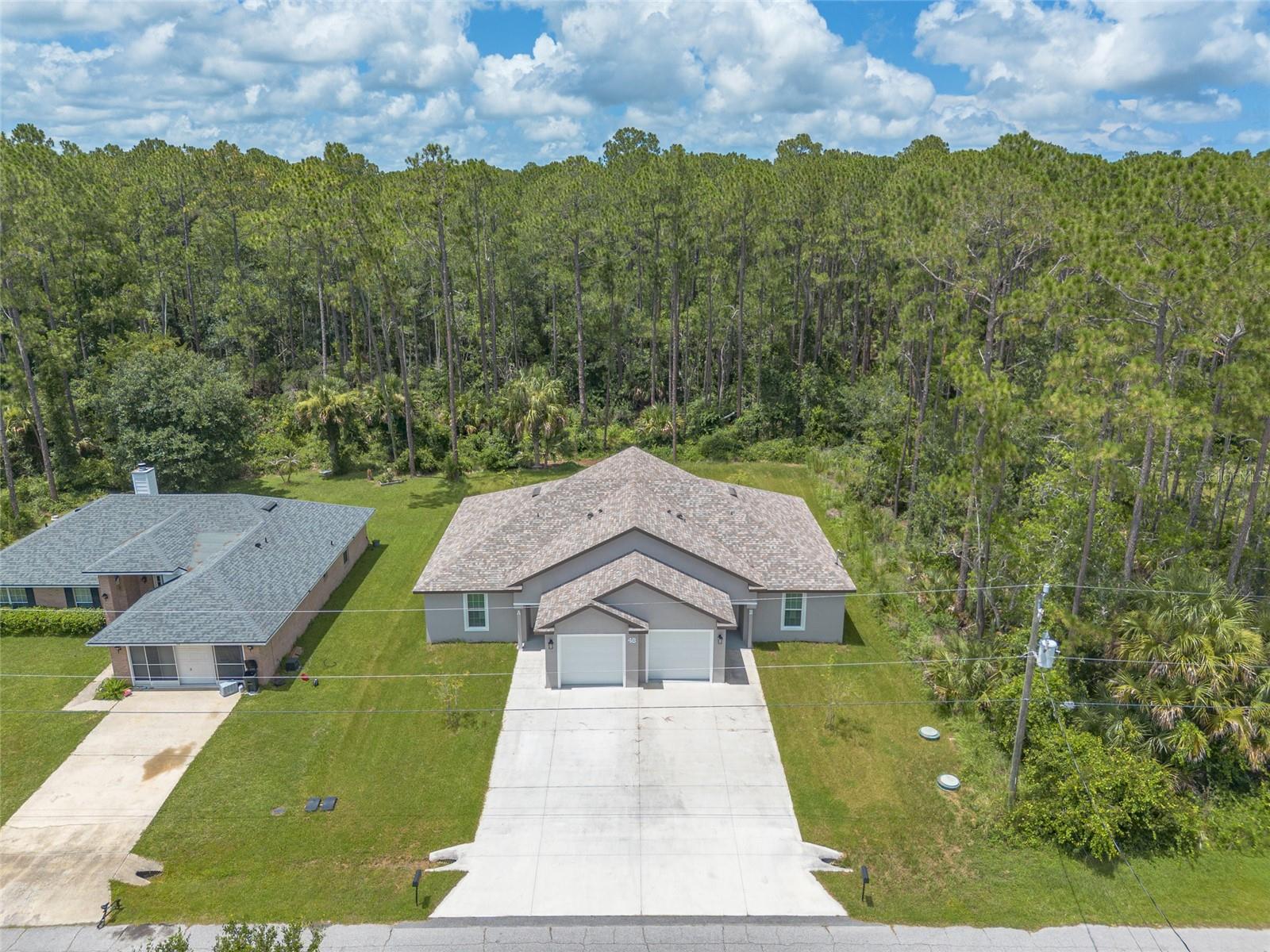 Duplex Alert!  Constructed in 2023 this 2,376 sq. ft. concrete block home sits on .23 acres in Palm Coast, FL.  Each unit offers 5 rooms, 3 bedrooms, 2 bathrooms and a deep 1 car garage.  The units mirror each other with an open floor plan featuring high ceilings, a kitchen with white shaker cabinetry, a center island, granite counter tops and stainless appliances overlooking the family room.  There is also LPV flooring throughout.  Each apartment has a separate covered patio facing the back preserve along with separate electric and water meters.  Come check it out today! This property is eligible under the Freddie Mac First Look Initiative through 8/13/2026.  Owner Occupants, non-profit and Neighborhood Stabilization Program offers will be considered FIRST LOOK.  Buyer to pay doc stamps. There are no warranties expressed or implied.  All measurements are approximate.  Sq. footage received from the tax rolls.  All information recorded in the MLS is intended to be accurate but cannot be guaranteed.  Buyers should check zoning for rental restrictions.