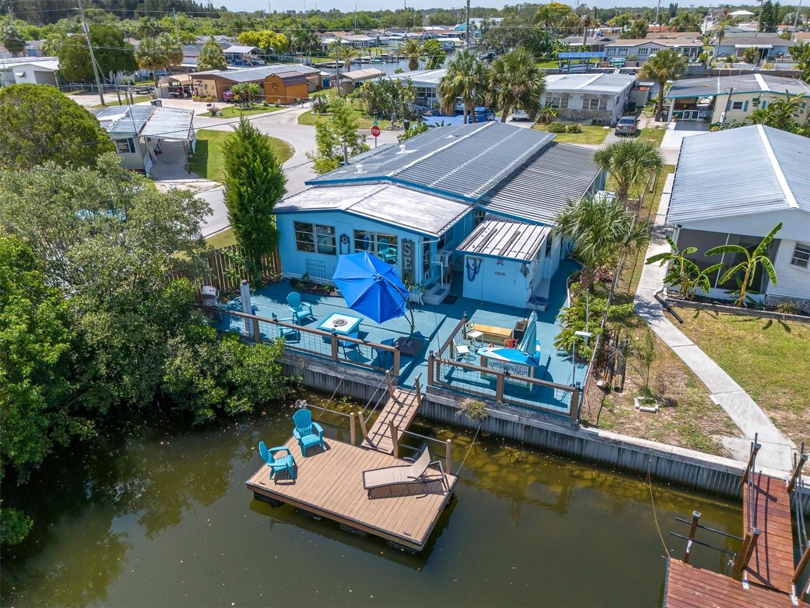 This adorable, Florida style bungalow canal home is now available in Signal Cove, Hudson! This home is fully furnished & MOVE IN READY! This open floorplan home is airy, extremely roomy & would be a great full time or as a vacation getaway.  It is  direct access to the  Gulf waters w/no bridges! A "boaters" dream that you can be out in the gulf in less than 5 minutes! This beautiful double-wide manufactured home is on 50 feet of canal water, a corner lot & has 2 bedrooms & 2 bathrooms.  It features a spacious, open, living room, a separate dining room with built in cabinets & an eat-in counter, over looking the kitchen area . A AC/Heat mini split is located in the living room & it also has a electric fireplace. This home has lots of windows & natural light!  Includes a inside laundry area & small exterior porch near the kitchen.  Plenty of extra storage is located throughout this home. The main hallway bathroom includes a shower/tub combo & has a nautical style. The very, spacious Master Bedroom has a AC/heat Mini Split, a large walk-in closet & a vanity sink with separate access to the shower & bathroom area. This Jack and Jill bathroom connects to the sunny, Florida Room on the canal side. A great room for entertaining, awesome views, which includes a built in bar, Trundle bed & can easily serve as a office, bonus room or extra guest room. This room has an AC wall unit with a heating element.  New vinyl plank flooring throughout.  The Florida room flows to the beautiful back yard on the canal side, continuing the entertainment area! A surfboard bar area overlooks the water, a firepit with a versatile cover that doubles as a table & a classy enclosed fence surrounds the entire seating area in this semi private patio. The large, wood, 16x6 floating dock is 3 years old. There is a large shed to store all the toys for easy access & a outside shower attached. A walkway leads to a covered breezeway, which provides a spacious area for entertaining, games & is enclosed for privacy. This area flows to the covered carport, which serves as the home's main entrance. Amply parking is available on this home. If you are looking for a beautiful home that is great for entertaining, tastefully furnished, a boater's dream with access to the Gulf in 5 minutes, enjoy those beautiful Gulf Coast sunsets &  has everything you need to start living the Florida lifestyle, this is it! 
The Signal Cove subdivision also has an island & sandbar located at the entrance of the channel. It is the only island/sandbar located in Hudson, making it a local favorite where you can meet family, friends, neighbors & bring your pup to play. In Signal Cove you own the land & home. NO lot fees. NO mandatory HOA fee, just a $245 optional fee for a "year", that allows you access to the private boat ramp. The subdivision has a clubhouse that features many fun events & activities throughout the year & also allows it to be rented for events. This is a golf cart community which often holds Golf cart events & is only a few minute cart ride to Hudson Beach. Hudson is centrally located to many options for restaurants, shopping, hospitals & doctors. 
Whether you're looking for a year-round residence, winter retreat, vacation home or investment opportunity, this property delivers outstanding value and Florida style living waterfront living at an incredible price. 
Come & check it out! Cash only. AS IS with valid POF. Buyer and the buyer's agent must verify all measurements.