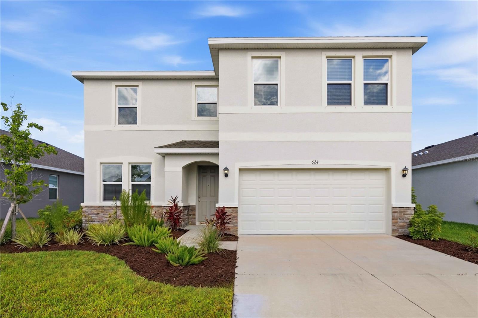 Situated in the highly desirable, gated community of Coddington within East Bradenton’s booming corridor, this meticulously maintained, 2025-built "Coral" model offers a flawless, turn-key alternative to new construction—complete with the massive financial advantage of a paid-in-full CDD bond. The home showcases high-end contemporary finishes throughout, featuring warm wood-look flooring that flows seamlessly across a sun-drenched, open-concept layout. At the heart of the home is a chef-inspired kitchen beautifully appointed with striking veined stone countertops, an oversized central island, crisp white shaker cabinetry, a classic subway tile backsplash, and sleek stainless steel appliances. Designed with ultimate structural flexibility, the floor plan includes four spacious bedrooms, three bathrooms, a dedicated downstairs den/office, and a massive upstairs bonus living room. The luxurious primary ensuite serves as a private, spa-like oasis, boasting a matching dual-sink stone vanity, a deep soaking tub framed by natural light, and a separate walk-in shower. Step through the expansive sliding glass doors to a covered lanai and a perfectly manicured lawn that captures a serene, picturesque lake view. Beyond the property's pristine condition, significant built-in savings, and neighborhood amenities, the location is unbeatable. Situated directly across the street from the highly rated Gene Witt Elementary School, minutes from outdoor adventures at Lake Manatee State Park and Rye Preserve, and just a short drive from premier shopping at the UTC Mall and the world-class beaches of Anna Maria Island.