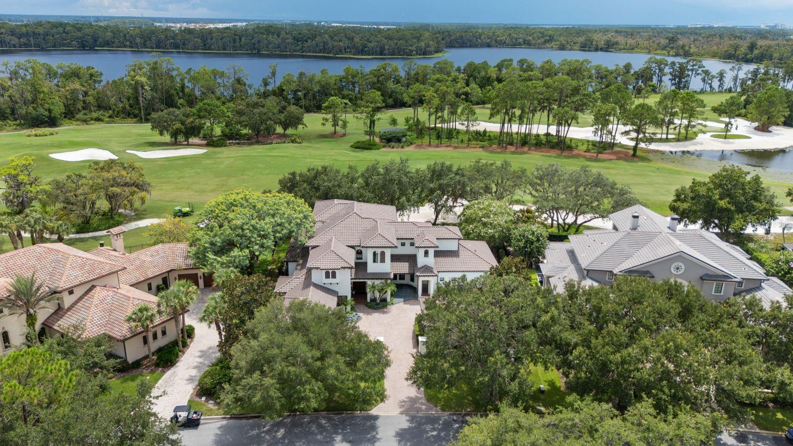 One or more photo(s) has been virtually staged. Nestled along the 12th fairway of Lake Nona Golf & Country Club's famed championship golf course, stunning panoramic fairway and water views provide the backdrop for this gorgeous estate within one of Central Florida’s most sought-after private communities. Originally built in a Mediterranean style, the residence has just undergone a comprehensive renovation by Akers Custom Homes, featuring an expertly reimagined floor plan, a new epicurean kitchen, remodeled bathrooms throughout, the addition of a second-floor laundry suite, and a fifth private ensuite bedroom. The exterior received a new roof, fresh exterior paint, Sierra Pacific windows and doors, and a newly designed saltwater pool and spa. 
Custom double doors open to the home’s welcoming foyer, which introduces the thoughtful floor plan where formal and casual living spaces are enhanced by natural light and golf course views. The elevated interior design strikes the perfect balance of sophistication and warmth with new European white oak hardwood flooring and custom cabinetry throughout, and Lutron lighting integration for intuitive whole-home control. The chef’s kitchen showcases an all-new Viking appliance suite, including a 48” dual-fuel range with six burners, griddle, and double ovens, a 48” built-in refrigerator, professional dishwasher, and matching hood. A center island with Kohler prep sink, a walk-in pantry and a breakfast nook complete the space.
The first-floor owner’s suite offers a serene retreat with dual walk-in closets, a reading nook, and direct access to the lanai. The spa-inspired bath highlights a freestanding soaking tub, custom vanities, and an oversized glass-enclosed shower. The second floor is comprised of three generously sized en suite bedrooms, a dedicated study/office, bonus/media room and access to an expansive covered balcony.  
Outdoor spaces are designed for entertaining and recreation, offering multiple golf course vantage points, a new saltwater pool and spa, and an integrated sports court with basketball hoop. Additional features include two expansive laundry suites, indoor and outdoor gas fireplaces, and garage space for 3 cars and 2 golf carts with built-in cabinetry, sink, and climate-controlled mini-split system.