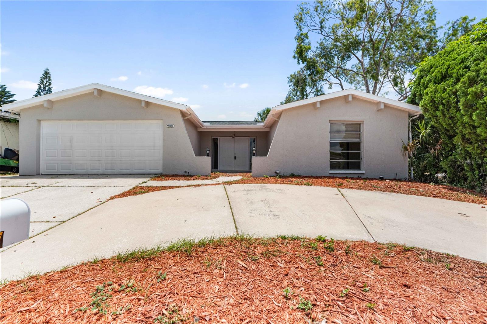 Welcome to 9307 Richwood Lane in Port richey.  This 3 bedroom 2 bath 2 car garage home has been refreshed and updated.  You will enjoy the extra parking with the circular drive.  Coming up to the front entrance with fresh landscaping, you enter the home through double doors into a foyer.  A large sunken living room has sliders to the fenced backyard.    New Paint interior and exterior.  New flooring.  Updated appliances, kitchen and bathrooms.  The home also has a huge lanai off the back to enjoy th Florida lifestyle.  This home is ready for its next owners!