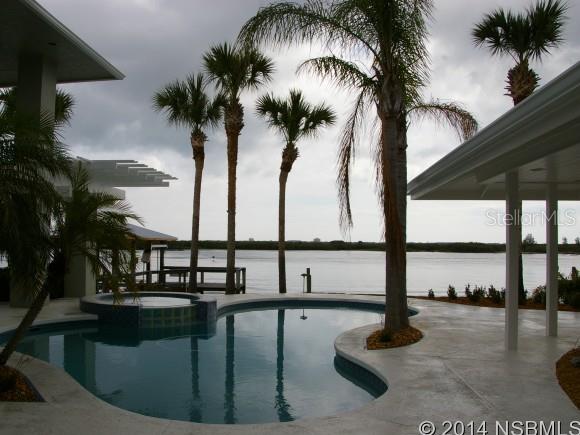 REDUCED $150K. Completely renovated inside and out! This magnificent Direct Intracoastal Riverfront pool home aims to please with 16 rooms and several outdoor leisure areas, including a covered boat DEEP WATER dock with lift with power/water, fish-cleaning station and in-water slip. Private gated island on the Intracoastal Waterway shared with the historical and prestigious Smyrna Yacht Club. Gourmet kitchen with center island, custom wood cabinets, granite, stainless steel high-end appliance package, pot-filler, butlers pantry, three living rooms (each with panoramic views)m,4 fireplaces (3 gas with remote), tile-wood-carpet flooring, vaulted ceilings with gorgeous paddle fans, free-form heated pool & spa, his & her offices, built-ins, second floor boasts a private master bedroom suite with private balcony, California-Closet Walk-in, luxury bath with heated towel racks, frameless glass shower, metal roof, Anderson windows, hurricane shutters, three separate a/c units, new ductwork, 2 water heaters (one tankless gas), second master suite has a 2-person jacuzzi tub with a rain shower. Included in one of the bedrooms is a kid-friendly loft. New fan-design paver driveway, Diamond-Brite pool finish in pool spa, new commercial heater for spool/spa, outdoor shower, lush tropical landscaping, irrigation sys, landscape and home lighting, paver walks, security sys and all new aluminum roof. Garage has epoxy flooring with space-saver wall system. Home professionally renovated and overseen by professional decorators for finely-appointed finishes, fixtures & window treatment. One-of-a-kind Architect-Designed! ;Water: City