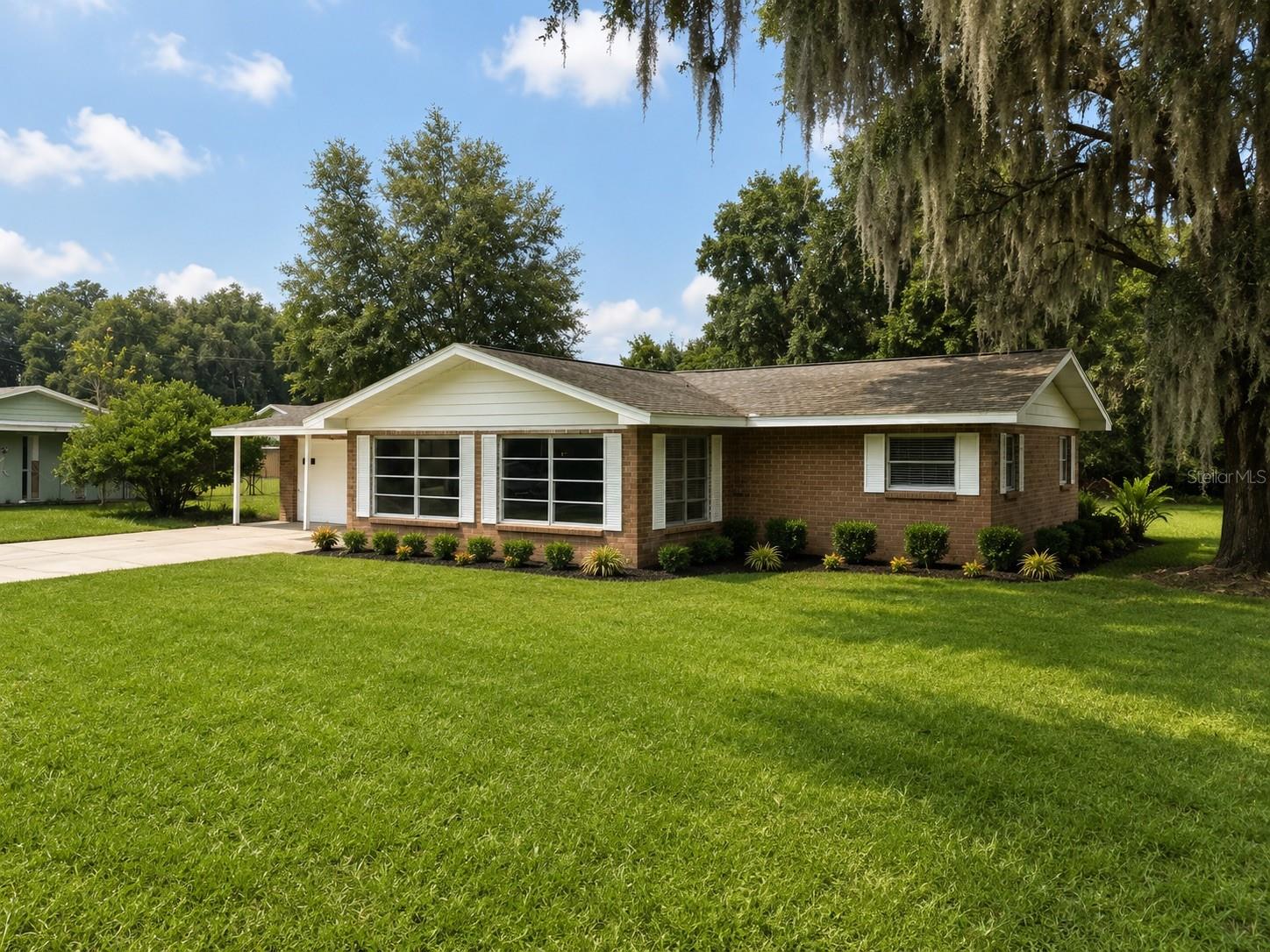 Virtually Staged. 2/2 updated kitchen, solid surface counters with full height, backsplash Terrazzo luxury vinyl plank flooring. Real wood paneling. Architectural shingle roof, oversized garage huge lot with lots of room for entertaining or gardening, oversized sunroom, as you walk in through the front door