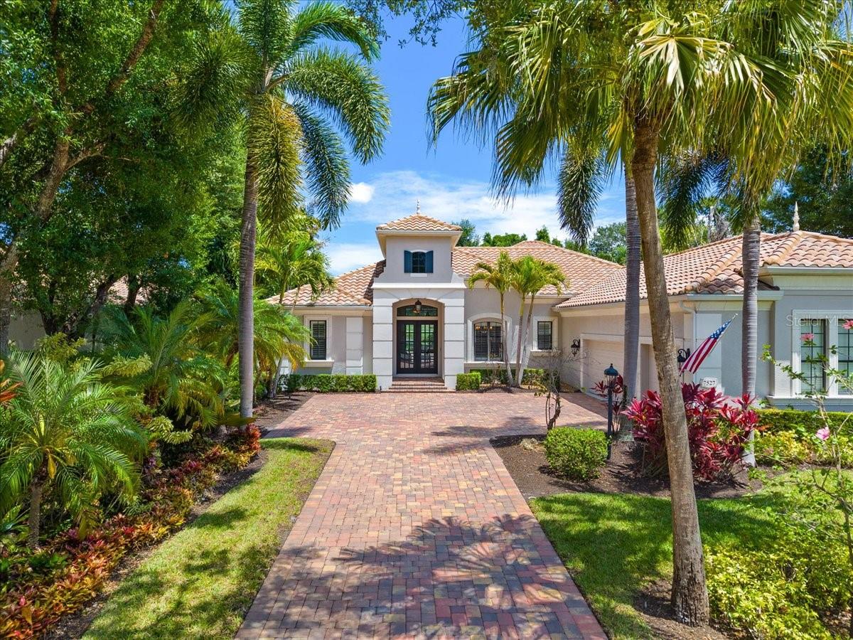 Ideally positioned within the highly sought-after Greystone enclave of Lakewood Ranch Country Club, this beautifully appointed residence offers an exceptional blend of sophistication, comfort, and sweeping golf course and water views. Featuring 4 bedrooms, 4 full baths, a spacious bonus room, and a dedicated office, the home is thoughtfully designed for both everyday living and elegant entertaining.
At the heart of the home, the kitchen serves as a true centerpiece, featuring a six-burner gas cooktop, Sub-Zero refrigerator, and spacious walk-in pantry. It flows seamlessly into a butler’s pantry with a wine refrigerator, connecting to a refined formal dining room and an inviting living space filled with natural light. The owner’s retreat is privately positioned on its own wing on the main level, offering dual custom walk-in closets and a spa-inspired bath with separate vanities, a freestanding soaking tub, and a walk-in shower. Guest accommodations are thoughtfully arranged, with two bedrooms on the main level sharing a full bath, while a third guest suite upstairs enjoys access to its own bath—ideal for visitors seeking privacy. The upper level also features an expansive bonus room, perfect for a media room, game room, or additional lounge, enhanced by some of the most captivating golf course views in the community. A dedicated office or den is ideally situated at the rear of the home, offering tranquil water and golf course vistas with custom built-in shelving. Nearby, a full pool bath provides convenient access for outdoor living—an ideal setup for both work and entertaining. Outdoor living is equally impressive. The oversized covered lanai offers a comfortable space to relax or host, while the fully equipped outdoor kitchen—complete with a grill, sink, and beverage refrigerator—makes entertaining effortless. A heated saltwater pool and spa are complemented by a panoramic screen enclosure, allowing for uninterrupted views of the golf course and water. Perfectly positioned on a generous 0.32-acre homesite, the property offers both privacy and space within one of Lakewood Ranch’s most desirable maintenance-free neighborhoods. Additional features include an oversized three-car garage, Hunter Douglas blinds, a wine room, and custom closets throughout. Residents enjoy a gated community lifestyle with optional membership opportunities offering championship golf, tennis and pickleball, fitness facilities, resort-style pools, and a vibrant social calendar—all just minutes from Lakewood Ranch Main Street, Waterside Place, top-rated schools and Sarasota’s renowned beaches and cultural attractions.