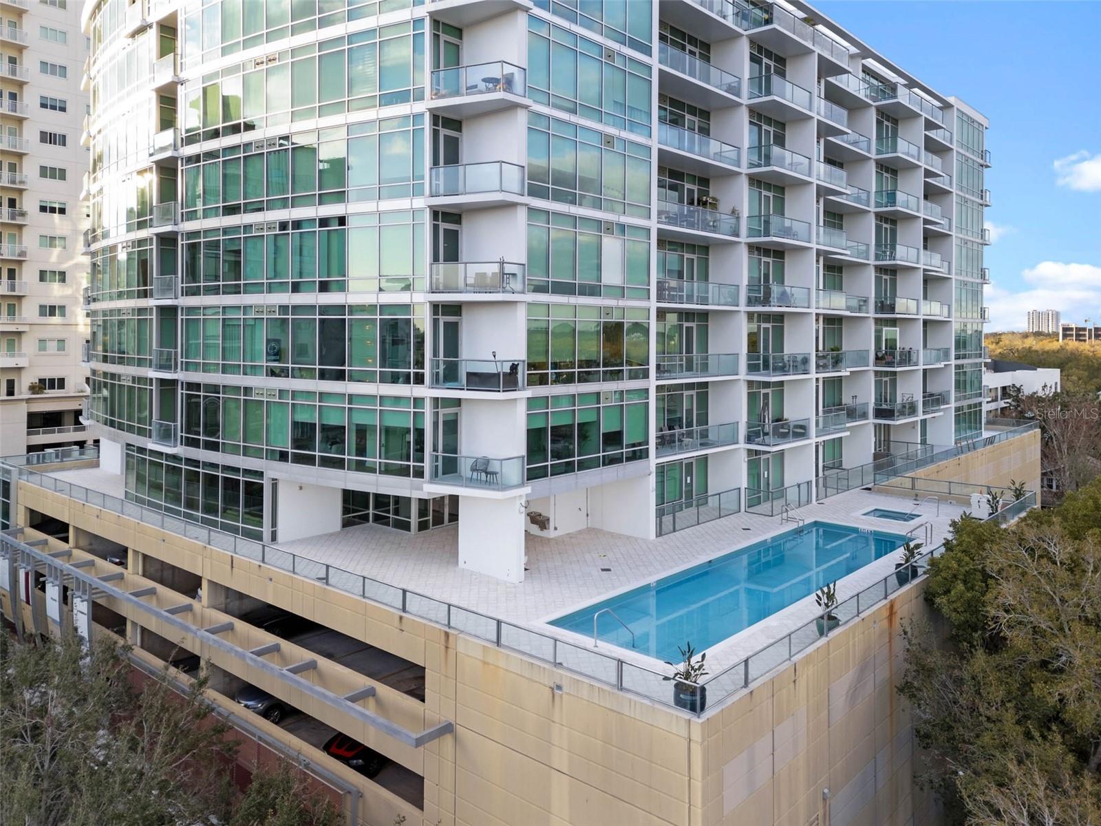 Welcome to 101 Eola, an iconic address in the heart of Downtown Orlando, where modern design meets an unbeatable walkable lifestyle in the highly sought-after South Eola–Thornton Park district. This 8th-floor residence is set within one of the city’s most recognizable architectural landmarks, a striking 12-story emerald glass tower just steps from Lake Eola Park, boutique shopping, dining, and Publix Urban Market. As you arrive, you’ll appreciate the convenience of your assigned parking space before heading up to your private residence. Stepping inside, you’re immediately welcomed by a fully remodeled interior where no detail has been overlooked. Brand new flooring flows seamlessly throughout the open-concept layout, while floor-to-ceiling windows showcase stunning cityscape views and fill the space with natural light. The kitchen serves as a sleek focal point, featuring all new cabinetry, quartz countertops with barstool seating, stainless steel appliances, a modern backsplash, and updated pendant lighting, creating a space that is both functional and beautifully designed for everyday living or entertaining. The bathroom has been tastefully updated with a quartz-topped vanity, and a nearby walk-in closet provides ample storage while maintaining a clean and streamlined design. The living space extends effortlessly to your private balcony, the perfect place to unwind and take in the city lights and skyline views. Residents of 101 Eola enjoy a collection of thoughtfully updated amenities, including a resort-style pool and sun deck, spa, fitness center, concierge service, and secured access, all designed to complement a low-maintenance, lock-and-leave lifestyle. Beyond the building, the location truly sets this property apart. Step outside to Lake Eola Park, where scenic walking paths, swan-filled waters, and year-round events create a vibrant backdrop to daily life. Explore the charm of Thornton Park’s brick-lined streets, discover local cafés and award-winning restaurants just minutes away, or enjoy performances at the Dr. Phillips Center for the Performing Arts. With close proximity to Downtown UCF, major highways, Orlando International Airport, and world-renowned attractions like Walt Disney World and Universal Studios, everything you need is within easy reach. This is city living at its finest, offering skyline views, modern updates, and a dynamic lifestyle all in one of Downtown Orlando’s most desirable addresses.
