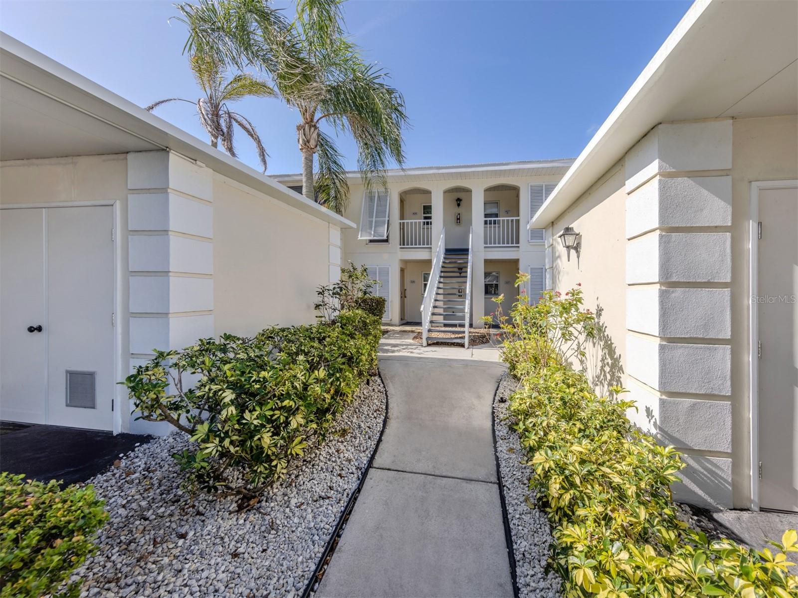 Ground floor! This updated turnkey, end ground-floor unit in the beautiful community of Plantation Golf and Country Club with beautiful westerly views! This well-maintained two-bedroom, two-bath gem spans 1,110 square feet and is brimming with charm. Updates include hurricane windows and doors, 2024 new roof, new carpet and more. The kitchen is a delight featuring solid wood cabinetry, gently used appliances, breakfast bar and sleek granite countertops that make every meal prep feel special. The great room design feels open and flows effortlessly, creating a cozy yet spacious vibe for everyday living and includes your dining room area and living space. The primary suite is at front of the home and includes a delightful nook that bathes in natural sunlight with walls of windows. This nook extends the primary’s cozy retreat, offering a bright and airy space where you can sip your morning tea, read a favorite novel or simply soak in the warmth of the Florida sun. This spacious primary also includes a built-in desk, large walk-in closet and private en suite with tall cabinetry and walk-in shower. Toward back of the home, you will find the spacious and bright second bedroom with built-in closet and sliding glass door access to the lanai and near the second full bath making this a tropical oasis for guests. Go outside to enjoy golf course views that add a touch of serenity or relax on the screened lanai or open outdoor patio, both boasting westerly-facing views for those dreamy Florida sunsets. The laundry room is conveniently on the lanai in the large storage closet. Including a covered carport and storage room, ideal for your golf clubs and beach chairs. Nearby are the community heated pool, clubhouse and numerous grilling stations. Membership at the Plantation Golf & Country Club is optional. The club offers two golf courses, tennis, pickleball, fitness and dining. The well-established, amenity-rich Plantation development is conveniently just minutes to pristine beaches of the gulf, downtown Venice, Atlanta Braves spring training Cool Today Park, new downtown Wellen Park, shopping, new Sarasota Memorial Hospital and dining.