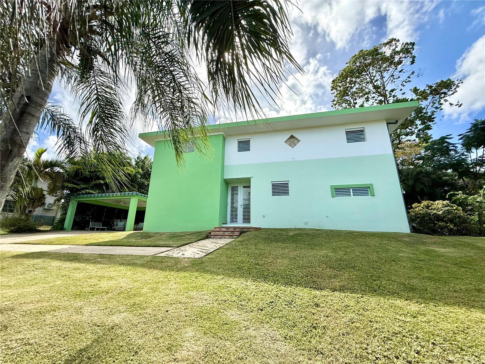 Located within the prestigious gated community of Hacienda Margarita in Luquillo, Puerto Rico, this beautifully renovated 4-bedroom, 2.5-bath residence offers an exceptional combination of modern comfort, spacious outdoor living, and a tranquil island setting. Surrounded by lush greenery and cooling trade winds, Hacienda Margarita is known for its privacy, resort-style amenities, and proximity to Luquillo’s beaches and El Yunque National Rainforest.

The home has been thoughtfully redesigned to feature a bright, open-concept layout, seamlessly connecting the living room, dining area, and kitchen—ideal for both everyday living and entertaining. The spacious modern kitchen is a standout, showcasing a large central island, elegant stone countertops, and high-end Café appliances, complemented by a walk-in pantry and a laundry room conveniently integrated next to the kitchen for added functionality.

All four bedrooms are located on the upper level, providing privacy and separation from the main living areas. Each bedroom connects to a shared balcony overlooking the expansive backyard, creating a harmonious indoor-outdoor feel and allowing natural light and breezes to flow throughout the home.

The private backyard is generously sized and offers ample space to create a true outdoor oasis, with room for a large pool, jacuzzi, and terrace—perfect for family gatherings, entertaining, or quiet relaxation. The front yard features a rolling terrain that enhances the sense of openness and privacy, accompanied by refreshing breezes and partial ocean views in the distance, adding to the home’s serene atmosphere.

Residents of Hacienda Margarita enjoy 24-hour gated security, a clubhouse, community swimming pool, tennis and pickleball courts, basketball court, playgrounds, and well-maintained common areas. The community’s elevated setting provides scenic views while remaining just minutes from Luquillo’s renowned beaches and food kiosks, major roadways, and a short 45 minutes drive approx. to San Juan international airport.

This property offers an outstanding opportunity to enjoy refined island living in one of Luquillo’s most desirable communities—ideal as a primary residence, vacation home, or long-term investment. Call now for a private appointment!