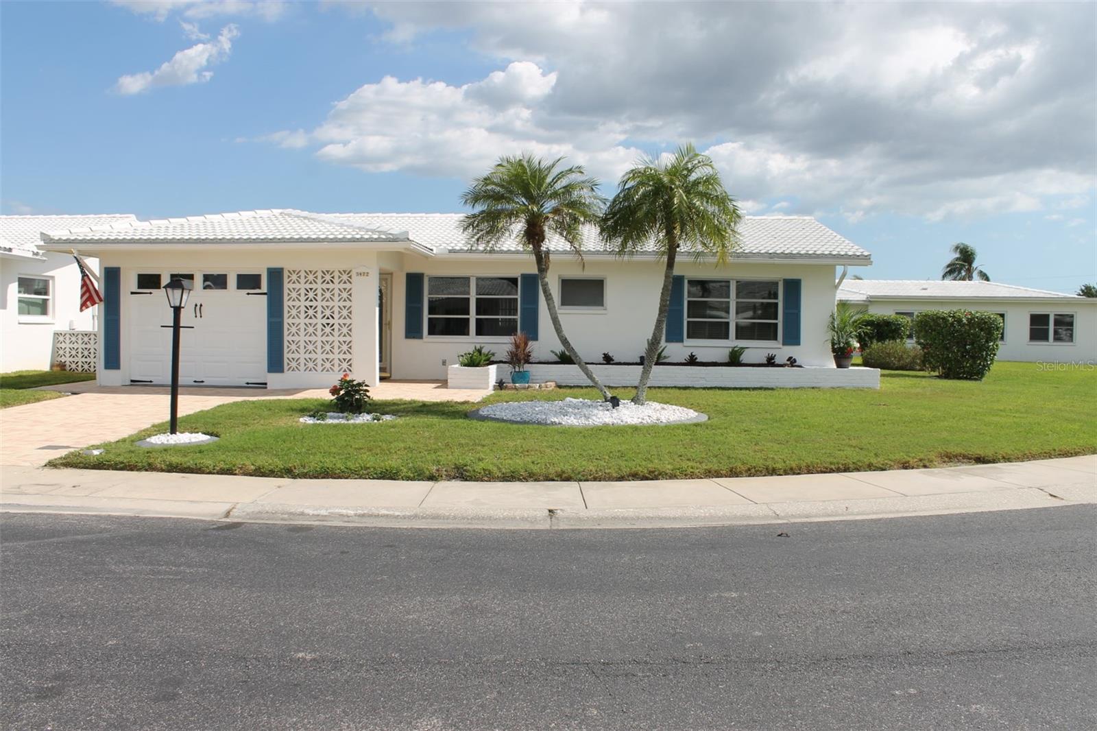 Beautifully Landscaped Curb Appeal at this Single-Family Home’s Corner Lot! 1328 sq ft heated Drayton Model with 2 Bedroom, 2 Bath, Large carpeted Enclosed Rear Porch, Rear Open Patio & a 1-Car Garage with a Pavered Driveway. This is a Move-In ready home located in Mainlands Unit 4, a 55+ community. The Florida Room has a Bank of Windows for plenty of light and a Breakfast Bar/Pass Thru to the Kitchen. Updates to the Kitchen include an abundance of Cabinets with pull out and soft closing drawers. Appliances: Whirlpool Dishwasher & Refrigerator with Ice & Water Dispenser, Whirlpool Stove with a Flat Cooktop & Convention Modes for Air Fry & Air Baking & a small Frigidaire Fridge. Other Updates to the home include the interior being freshly painted 2026; AC 2/2020; Water Heater 11/2020 with a power switch; Tiled Roof 5/2021, Pavered Driveway.

This Home is located in the desirable Mainlands of Tamarac in Unit 4. It’s a 55+, Golf Cart Friendly Community where The Mainlands Golf Course, Public Par 67 ‘Florida Links’ Style Course Resides. Mainlands of Tamarac has 7 Units (mini-subdivisions) each having their own Clubhouse, Heated Pool, Amenities & Social Clubs. Unit 4 does allow 2 pets (dog/cat) with a weight limit. Cats may not weigh more than 15 pounds at maturity.  Dogs may not weigh more than 35 pounds and not be more than 20 inches in height at maturity. You do not need to be 55+ to own the home although 1 permanent resident in the home does need to be 55+ with other permanent residents in the same home being at least 40. The Monthly Maintenance Fee is $480 which covers the Water, Trash, Sewer, Internet, Cable and more! The Exterior of the home, including the Roof & Lawn Maintenance are maintained by the Association. Utilities here in Unit 4 are below ground. 
Don't miss the opportunity to make this home your own as a winter home or year-round and experience the best of Pinellas County. The location offers convenient access to major highways, as a gateway to the culture, entertainment and sporting delights Tampa Bay has! To name a few - Pinellas County beaches are just a short drive away; World-class art galleries, theaters, and cultural events; Top-notch golf courses, tennis clubs, and water sports; Beautiful parks and nature preserves & Professional football, baseball, & hockey teams!