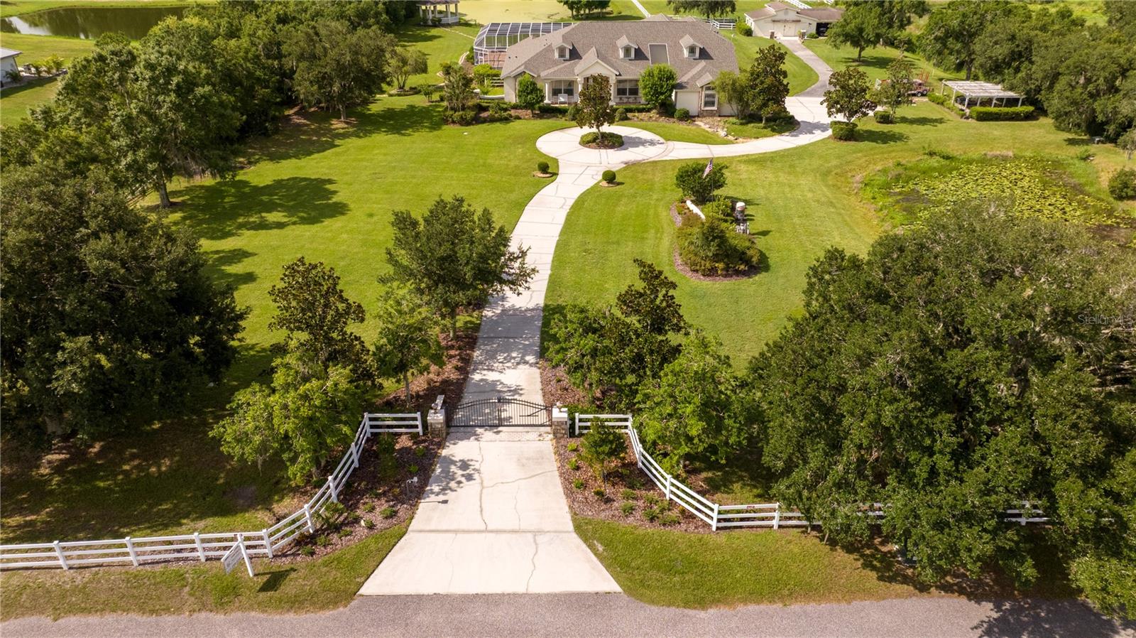A sprawling 6,349 sq. ft. luxury residence set on 5 pristine acres, this exceptional equestrian estate blends refined living, privacy, and country elegance within the exclusive, gated 5-home equestrian community of Canterfield Farms. Thoughtfully designed for both grand entertaining and everyday comfort, this home features four bedrooms, five baths, four living rooms, a home movie theater, executive office, exercise/flex room, and abundant storage throughout.
A dramatic formal entry welcomes you with polished travertine marble floors, soaring 12’ coffered and inlaid wood-beam ceilings, and a striking double-sided fireplace. To the right, the formal dining room is anchored by a radiant crystal chandelier; to the left, an impressive executive office offers a quiet retreat.
The chef’s kitchen is the heart of the home, showcasing high ceilings, two sinks, a pot filler, and generous prep and storage space. It flows seamlessly into the expansive great room, creating an ideal setting for gatherings. The first-floor primary suite is a true sanctuary, featuring a private glass atrium, rich wood floors, oversized tub, walk-in glassed shower, dual vanities, and a double walk-in closet.
With four distinct family rooms, there is space for every lifestyle need—from relaxation to recreation. All bedrooms are on the first floor.  Two guest rooms have a Jack & Jill bathroom with separate double vanities and a shared workspace. The fourth guest room or in-law suite is in a private cove with adjacent full bath and private living room.  The home movie theater with half bath elevates entertainment to a cinematic experience.
Outdoor living is equally captivating: a resort-style pool, gazebo overlooking the serene pond and fountain, and a cozy fire pit create a peaceful, picturesque environment.  For the horses or workshop needs there is a 3-stall concrete block barn, tack room, and four-car carport. 
Located in this gated community is a private equestrian center with boarding and training facilities. Nearby, miles of scenic riding and walking trails wind through Triple Creek Nature Preserve, Balm Boyette Scrub Preserve, and FishHawk Nature Preserve, offering endless outdoor adventures. Top-rated schools and convenient access to major roadways further enhance the appeal of this exceptional location.
Experience the rare combination of luxury, acreage, and equestrian living. Contact us today to schedule your private tour.