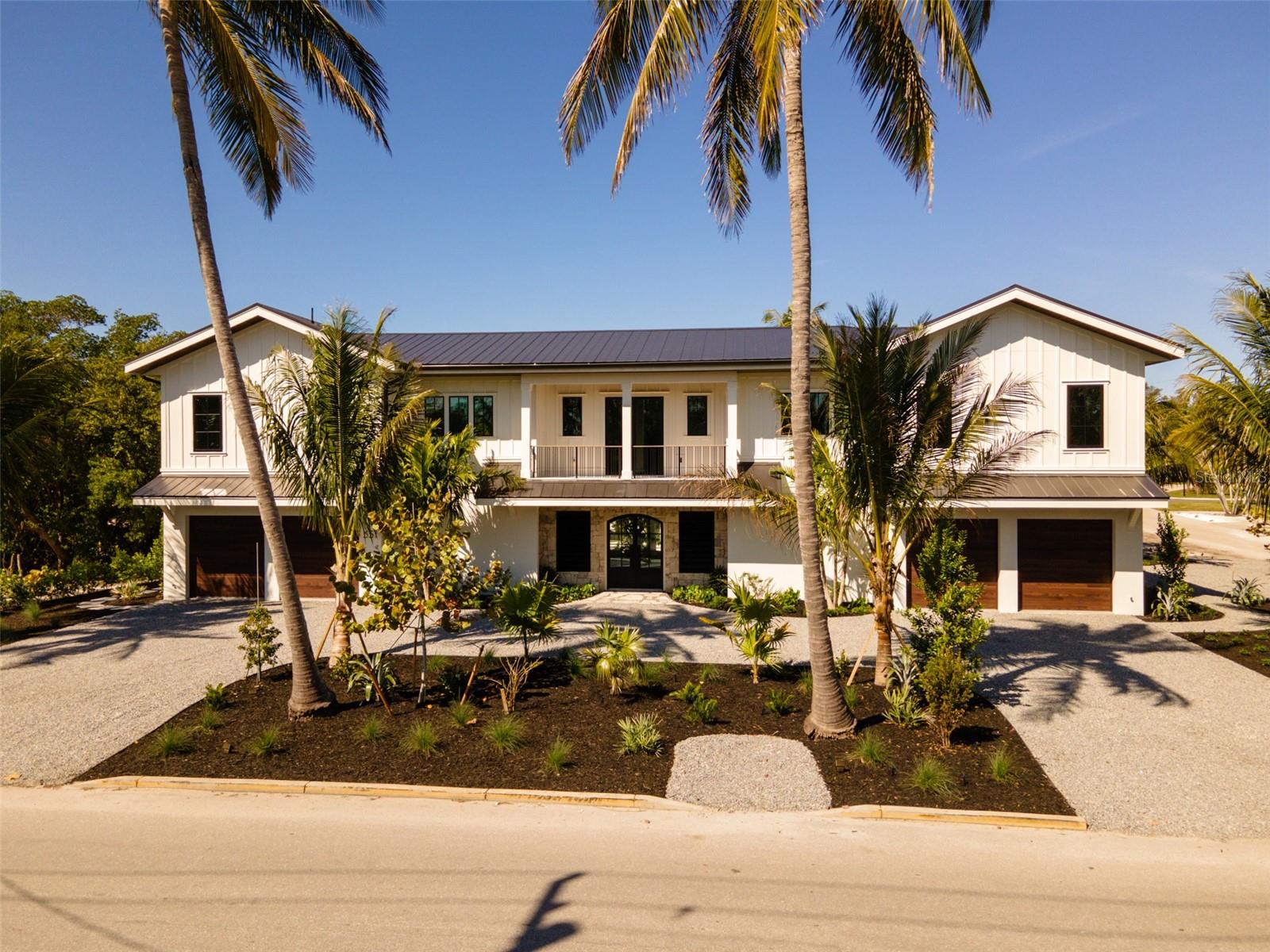 Ready for occupancy. This Coastal Elegance at its finest.  This new home features timely finishes including, hard wood flooring, custom cabinetry, high quality solid surfaces, custom mill work through out, and vaulted ceilings . There is a primary and secondary master suite and two en-suites. The home will have a private elevator, several covered lanais and an amazing tropical pool with spa surrounded by mature landscape. There is a full service outdoor kitchen on the lower lanie for entertaining pool side . For the boaters, there is canal access including a boat dock and 10,000 pound lift with easy access to the ICW and the Gulf of Mexico. Conveniently located in the Historic Village of Longboat Key you have easy access to the beach, which is a short 5 minute walk . You are also a short walk to three of the best local restaurants. . The home is furnished and ready to move into . As a bonus  a custom outdoor kitchen has just been installed to enhance your out door living.