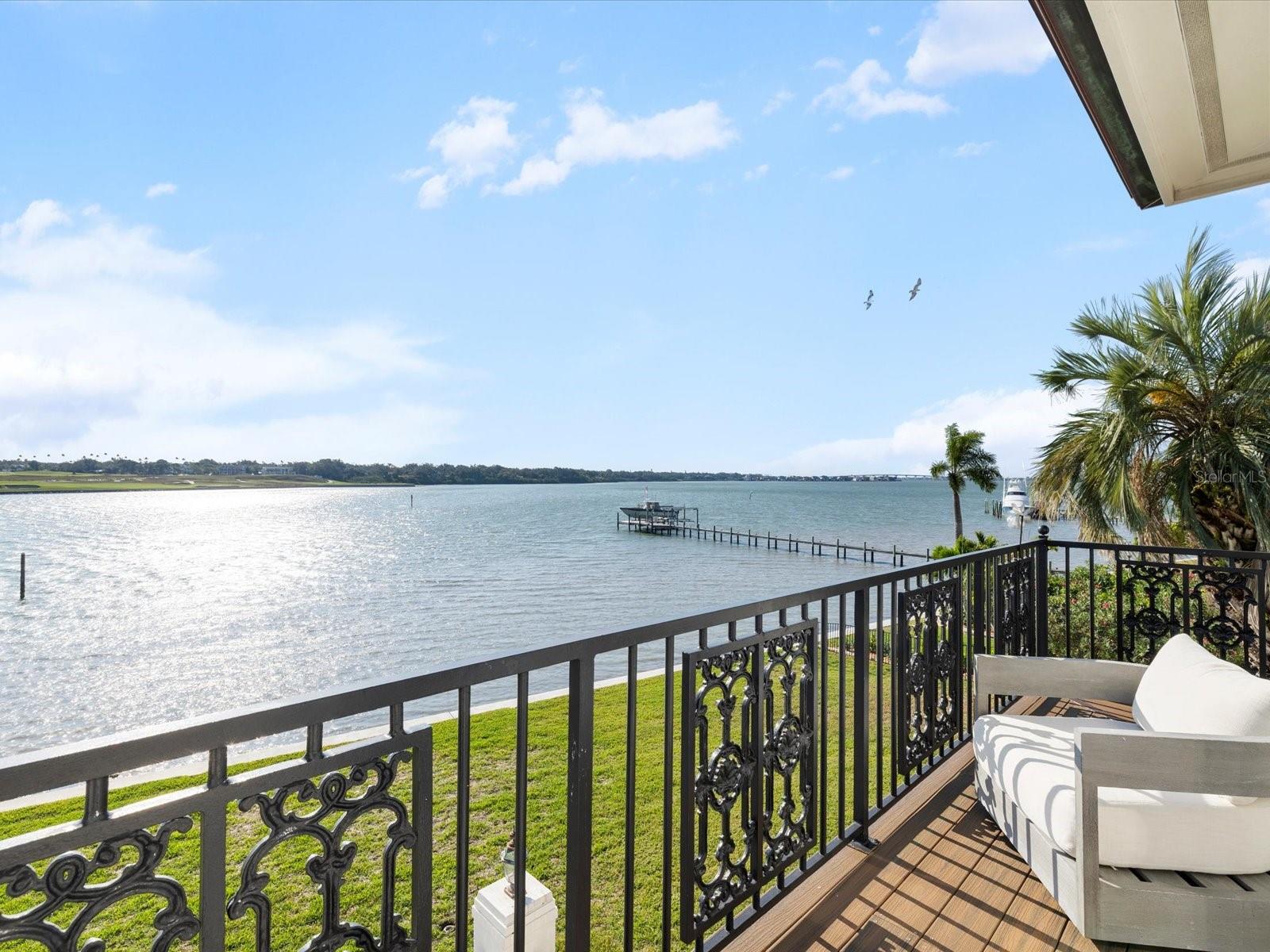 This private, world-class waterfront estate sits within the exclusive double-gated enclave of Belleview Island. Perfectly positioned on a rare double lot, the property offers breathtaking panoramic views of Clearwater Harbor and the historic Donald Ross–designed Belleair Golf and Country Club, Florida’s first golf course. A true boater’s paradise, the protected cove features a custom dock with a jet ski lift, along with 60,000 lb. and 80,000 lb. boat lifts, providing quick and direct access to Clearwater Pass and the Gulf of America. Inside, the custom-built residence showcases refined craftsmanship and elegant living spaces. A grand, custom staircase introduces the home and opens into an expansive great room designed for sophisticated entertaining, complete with a dining area, wet bar, custom built-ins, and sweeping water views. The gourmet kitchen offers a large island, custom cabinetry, granite countertops, a butler’s pantry, and a charming breakfast room overlooking both the bay and golf course. The second floor is a private retreat featuring a luxurious primary suite with its own balcony, vaulted ceilings, fireplace, and dual spa-caliber bathrooms—one with a walk-in shower and the other with a whirlpool tub—plus two walk-in closets. Three additional guest suites each include marble bathrooms and walk-in closets. Outdoor living is exceptional, with a beautifully designed pool house featuring an open wood ceiling, wine refrigerator, and grilling area, all overlooking an elegant paver pool deck. The 1,100 sq ft air-conditioned three-car garage offers high ceilings ideal for car lifts, while the landscaped grounds and custom paver driveway enhance the home’s grand presence. Engineered for long-term resilience, this elevated block construction features custom electric hurricane shutters, a whole-home Generac generator, and a new seawall (2023). The home further benefits from updated AC systems (all under warranty), a new pool and hot tub heater, tankless water heater, water softener, solar panels, LED lighting throughout, and numerous updated appliances. This exceptional residence combines pedigree, privacy, craftsmanship, and unmatched waterfront living. Secure your place in the winner's circle and experience one of Belleview Island’s finest estates.