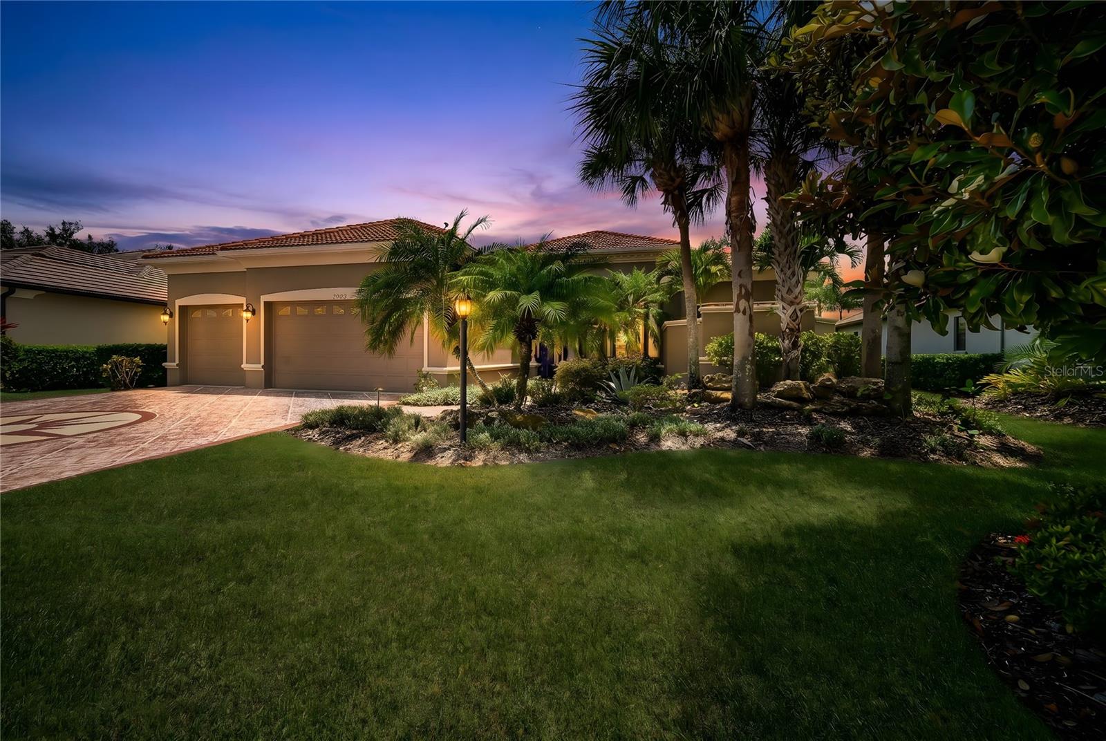 A home that lives like a private resort in the heart of Lakewood Ranch. Situated on a picturesque ¼ acre lakefront homesite in Greenbrook Village, this expansive 5-bedroom plus office and Media room, 4-bath luxury residence offers over 4,100 square feet of thoughtfully designed living space with exceptional indoor-outdoor flow and countless upgrades throughout. From the moment you arrive, the engraved driveway, mature landscaping, and dramatic evening landscape lighting create unforgettable curb appeal.
Inside, etched French doors open to soaring 12-foot ceilings, abundant natural light, tray ceiling details, and sweeping views of the pool and lake beyond. Designed for both entertaining and everyday comfort, the home features formal living and dining spaces, a spacious family room with disappearing sliders, and durable tile flooring throughout the main living areas.
The chef’s kitchen is beautifully appointed with quartz countertops, cherry wood cabinetry, newer appliances, a gas range, center island, and expansive breakfast bar ideal for gatherings large or small. The split-bedroom floor plan provides privacy for the luxurious primary suite, complete with direct lanai access, oversized walk-through closet, and a spa-inspired bath featuring dual vanities, garden tub, walk-in shower, and serene garden views from aquarium-style window. A private office or flex room, along with additional guest bedrooms and baths, complete the main level.
Upstairs, an oversized bonus room currently configured as a theater offers endless flexibility for a game room, lounge, or media retreat and is already plumbed for a future wet bar or kitchenette. Two additional bedrooms, a full bath, and a covered balcony overlook the sparkling pool and tranquil lake setting.
Outdoor living takes center stage with an impressive two-story screened lanai featuring programmable multi-color lighting, an infinity-edge pool with waterfalls and spa, shaded gathering areas, outdoor shower, and pre-plumbing for a future outdoor kitchen. The peaceful waterfront backdrop creates exceptional privacy and a true Florida lifestyle experience.
Additional upgrades include hurricane-rated windows and doors, a reinforced two-story pool cage, full-house generator, whole house water filter, tankless natural gas water heater, remote-controlled blinds, fresh exterior paint, and walkable attic storage with new 375-pound ladder access.
Perfectly positioned near Adventure Park, nature trails, playgrounds, dog parks, top-rated schools, Lakewood Ranch Main Street, UTC shopping and dining, Premier Sports Campus, golf, and the Gulf Coast’s renowned beaches, this home delivers space, luxury, and lifestyle in one remarkable offering.