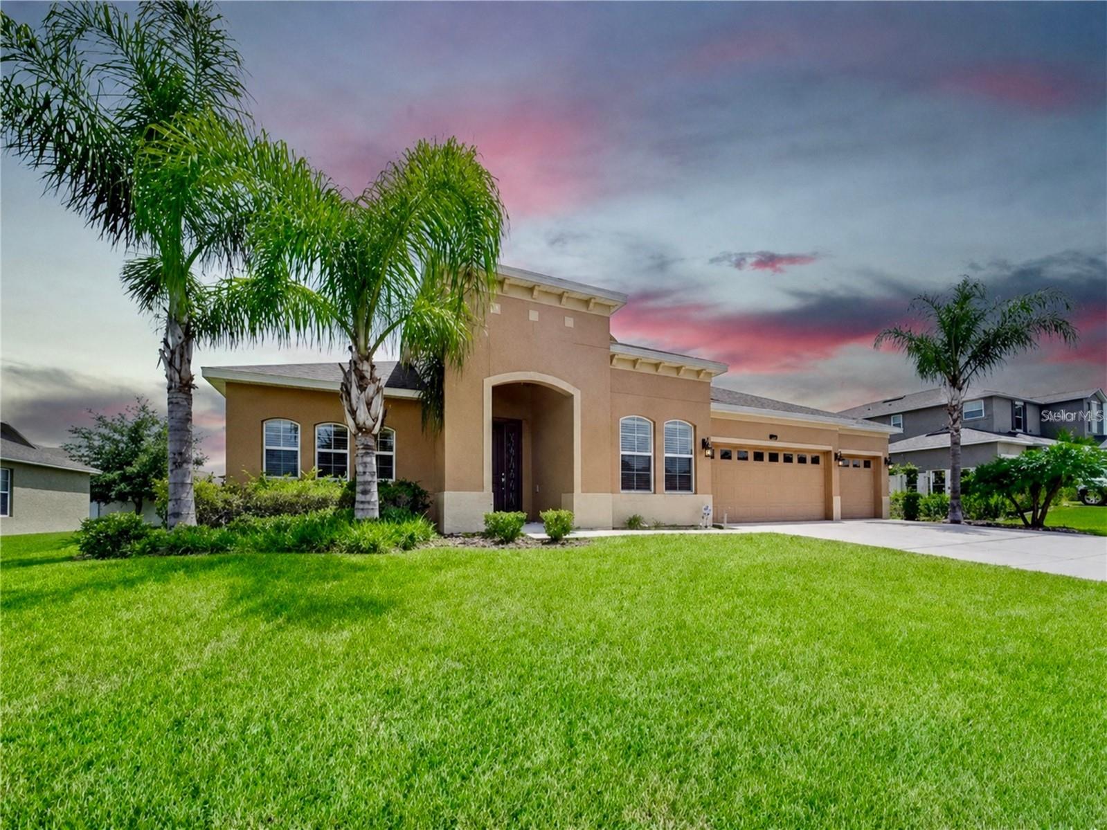 Some homes simply check the boxes. Others invite you to imagine an entirely new way of living, and this beautifully updated, custom-built residence in the gated Estates of Auburndale does exactly that. Framed by soaring palms and lush tropical landscaping, this four-bedroom, three-bath home with a three-car garage makes a memorable first impression and offers the space, style and relaxed Florida lifestyle you’ve been searching for.

Step inside and discover a home that feels open and welcoming. Nine-foot ceilings, architectural archways, fresh paint, new flooring, updated lighting and abundant natural light create an effortless flow through the main living and entertaining spaces. Whether hosting a lively gathering, enjoying a quiet evening or bringing everyone together for the holidays, the open-concept design keeps conversation and connection at the center of it all.

At the heart of the home is a kitchen designed to be as beautiful as it is functional. Granite countertops, 42-inch custom cabinetry, a glass-tile backsplash and pendant lighting create a polished setting, while the expansive center island and breakfast bar provide the natural gathering place every great home deserves. A dual-basin sink and new stainless-steel appliances complete the space. From quick weekday breakfasts to memorable dinners with friends, this kitchen is ready for every occasion.

When the day winds down, the oversized primary suite offers a private retreat with room to relax. Its spacious en-suite bath delivers a spa-inspired experience with a soaking tub, oversized framed-glass shower, recessed lighting, a generous vanity with a dedicated seated area and an impressive walk-in closet. Three additional bedrooms provide flexibility for family, guests, a home office or creative space. Two share a convenient Jack-and-Jill bathroom, while a separate guest bath adds comfort and privacy.

The Florida lifestyle continues outdoors on the extended, covered and screened lanai, an inviting setting for morning coffee, weekend meals, game-day gatherings or simply unwinding at sunset. Beyond the lanai, the spacious backyard is a blank canvas ready for a garden, play area, outdoor retreat or the future pool you have been envisioning.

Thoughtful features add even more value, including a three-car garage with room for vehicles, storage and hobbies; a security system; new paint; new flooring; new lighting fixtures and more. The careful updates allow you to move in, unpack and begin enjoying it from day one.

Life in the Estates of Auburndale extends well beyond your front door. Inside this gated community, residents can enjoy resort-style amenities including a community pool, basketball court, playground and walking trails, giving you more ways to stay active, gather with friends and make the most of the Florida sunshine.

This is more than a spacious, updated home; it is the backdrop for the life you have been waiting to create. Picture dinners around the kitchen island, laughter flowing from the living room to the lanai, peaceful evenings in your private suite and weekends spent enjoying the community amenities. Homes that combine this much space, flexibility, comfort and character are not easy to find. Schedule your private showing today and experience why this Estates of Auburndale home may be the one you have been waiting for.