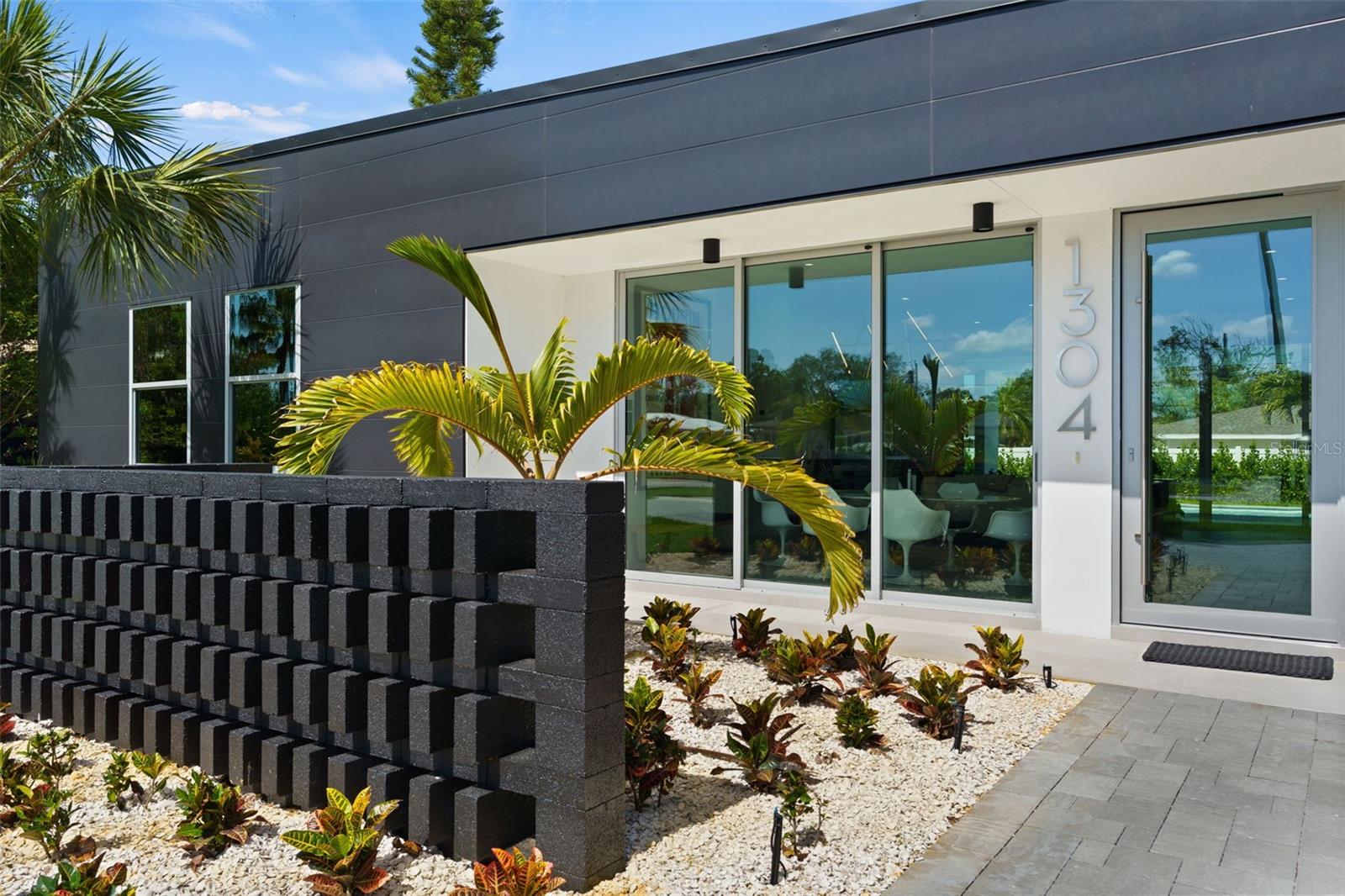 From the West Coast of California to the West Coast of Florida, this Belleair Home has Hollywood Hills written all over it!  Experience the carefree lifestyle that you have been dreaming of in this modern marvel.  Located in the alluring Town of Belleair and within just a few blocks of the iconic Pelican Bay Golf Club.  Take a stroll on the neighborhood sidewalks to the Community Parks and Sport Courts reserved exclusively for the residents of Belleair.  This exquisite four-bedroom pool home was imagined by a Beverly Hills designer and constructed with care in one of Pinellas County’s most Charming Communities.  Built to enjoy and withstand all of nature’s elements, this home is wrapped in Nichiha cement fiber panels - "Japanese Rain Screen" - and located in Flood Zone X, a non-evacuation zone.  The ten foot ceilings and impact glass windows flood the space with glorious light.  From the courtyard entry, the main living area is a wide-open space drawing the inside out and the outside in.  This space includes a state-of-the-art kitchen with waterfall quartz countertops over a large center island and high-end appliances set on a sleek backdrop.  The great room has six sliding glass panels that open to a covered sanctuary and resort style pool.  The primary suite has access to the pool, an ensuite bath and two walk-in closets.  The primary spa bath has a walk-in tiled shower, a generous soaking tub and a floating double vanity. The second suite has a view of the pool, a walk-in closet and a private ensuite bath with glass enclosed shower.  The third and fourth bedrooms each have custom closets and share a luxurious full bath.  The powder bath is a surprising contrast of matte black in this otherwise neutral palette.  Beyond the kitchen, following a wall of built-in pantry cabinets, the large laundry room has loads of storage space and provides a mudroom entry from the attached two car garage – keeping this minimalist home more organized than you ever thought possible.  The outdoor living space flows seamlessly from the great room and bedroom suites, offering additional square footage in this year-round oasis.  Covered Living and dining areas and an outdoor kitchen lend elegant poolside entertainment.  Windows are tinted for privacy and energy efficiency. Natural gas powers the range, water heater, pool heater and BBQ grill.   This Belleair Home is just minutes from Belleair Beach and St. Pete Clearwater International Airport.  Just a thirty-minute drive to Downtown St. Pete or Tampa.
