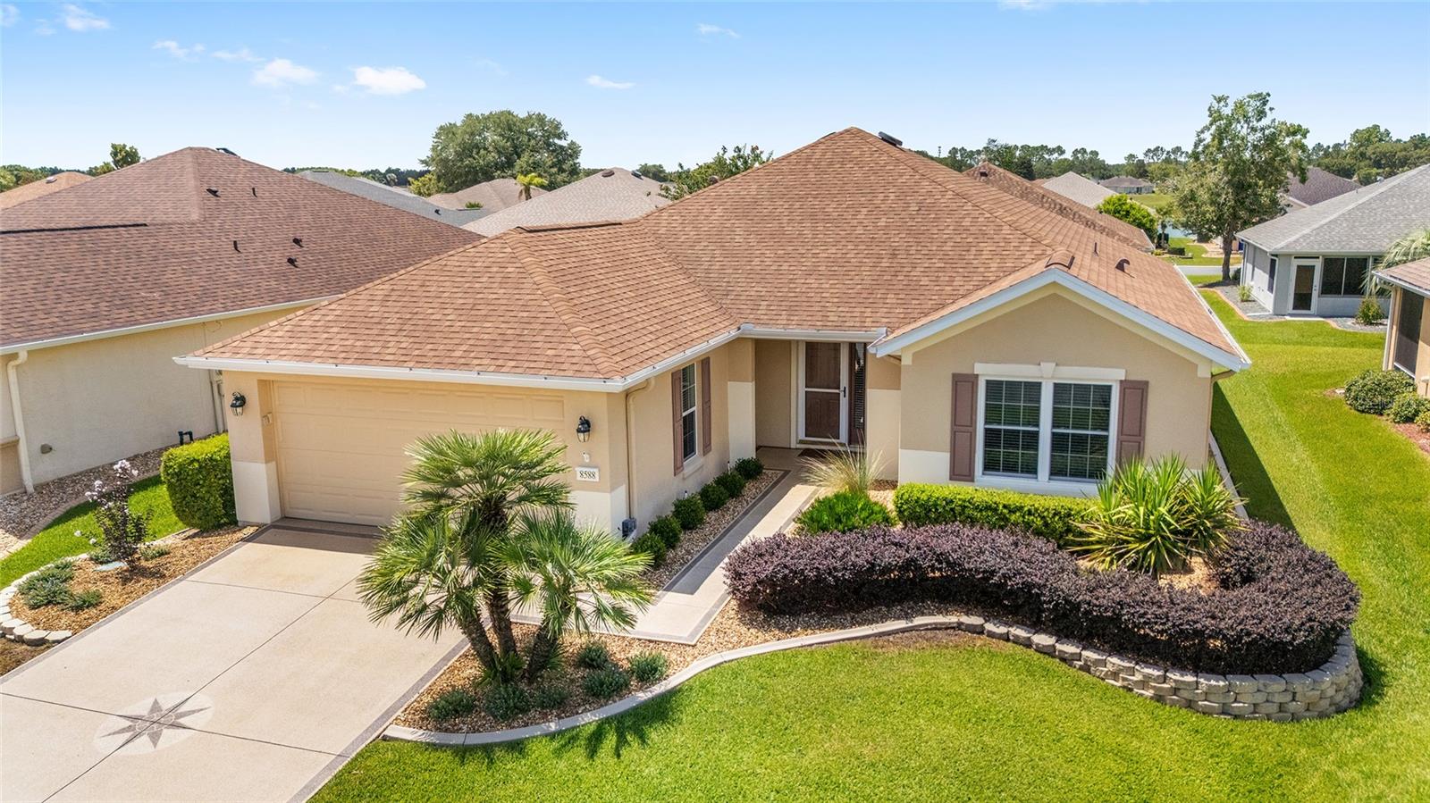 Welcome home to this beautifully updated Citation model with a designer-painted, textured driveway, front walk, and porch. Facing north, the beveled glass front door and storm door bring natural light into the foyer, while mature landscaping and hacienda walls add inviting curb appeal. This one-owner home features many updates, including new windows in 2016, newer appliances with a Thor range, Quartz kitchen countertops, a large kitchen sink, laminate and ceramic tile flooring, French doors, and built-ins in the Library/Den. The home has also been re-piped. The spacious primary suite offers an en suite bathroom with a custom-built shower and private water closet. The exterior was painted within the past year, and the screened lanai is under roof with a knee wall. The extended 4’ garage includes an epoxy floor, workbench, pull-down attic storage, slop sink, and automatic overhead garage screen door. Major updates include a roof replaced in 2021, HVAC updated in 2017, and water heater replaced in 2025. Located in the beautiful, tree-canopied Del Webb Spruce Creek Golf and Country Club, this 55+ community offers outstanding amenities and four 9-hole golf courses. Conveniently situated just north of The Villages and south of Ocala, the home is close to fine dining, shopping, and entertainment. Come see this beauty today!