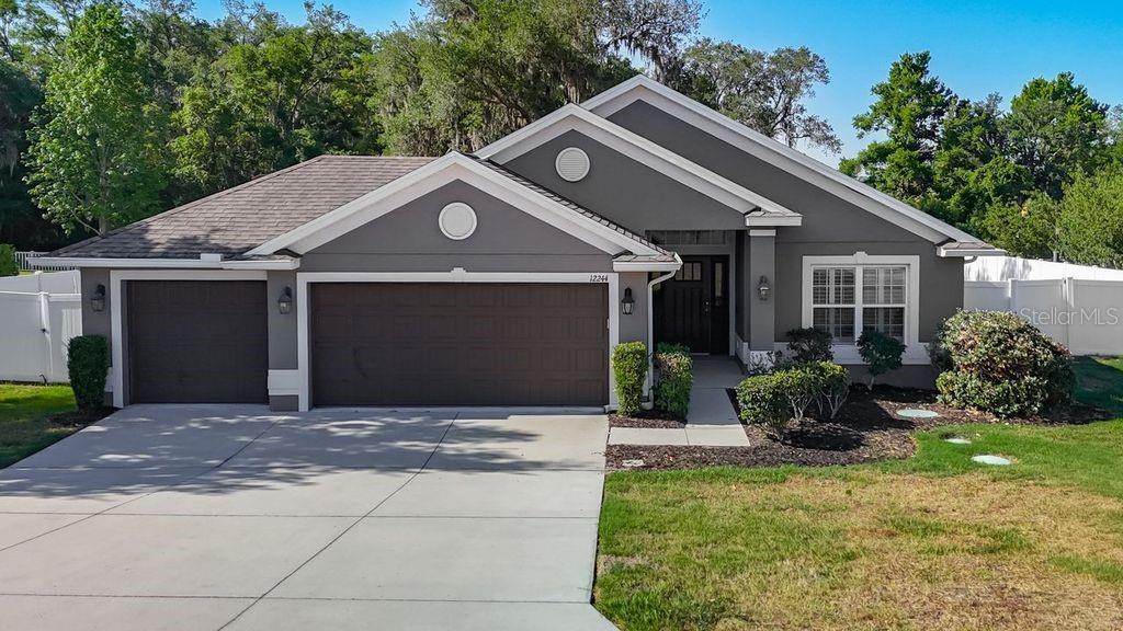San Antonio – Oak Glen – Discover this beautifully maintained 4-bedroom, 2-bath home, offering 1,835 square feet of thoughtfully designed living space and a sought-after 3-car garage on nearly half an acre. Built in 2016, this residence showcases contemporary finishes, smart design, and everyday comfort. Step inside to an open, airy floor plan enhanced by vaulted ceilings that fill the home with natural light and a sense of spaciousness. The chef’s kitchen features stainless steel appliances, granite countertops, rich wood cabinetry, a closet pantry, and a breakfast bar that flows seamlessly into the great room - ideal for entertaining or keeping connected with loved ones. Enjoy casual meals in the cozy dining nook or host gatherings in the separate formal dining area, offering flexibility for every occasion. The split-bedroom layout ensures privacy, with wood-look tile flooring in the main living spaces and plush carpeting in the bedrooms for added comfort. Retreat to the primary suite, complete with a generous walk-in closet and a spa-like en suite bath featuring dual sinks, a garden tub, and a walk-in shower. Additional highlights include an indoor laundry room with a washer and dryer, abundant storage, and a spacious three-car garage for vehicles, hobbies, or extra belongings. Experience Florida living year-round on the screened rear lanai overlooking an expansive backyard—perfect for creating your own outdoor oasis, whether that’s a pool, garden, or entertainment space. This move-in-ready home offers the ideal blend of style, space, and opportunity. Ideally located just minutes from Saint Leo University and the Lagoon, and close to top shopping and dining destinations including The Grove at Wesley Chapel, Wiregrass Mall, and Tampa Premium Outlets. Plus, enjoy an easy commute with downtown Tampa approximately 30 minutes away. Schedule your showing today to embrace the tranquility of country living with the convenience of city amenities close by.