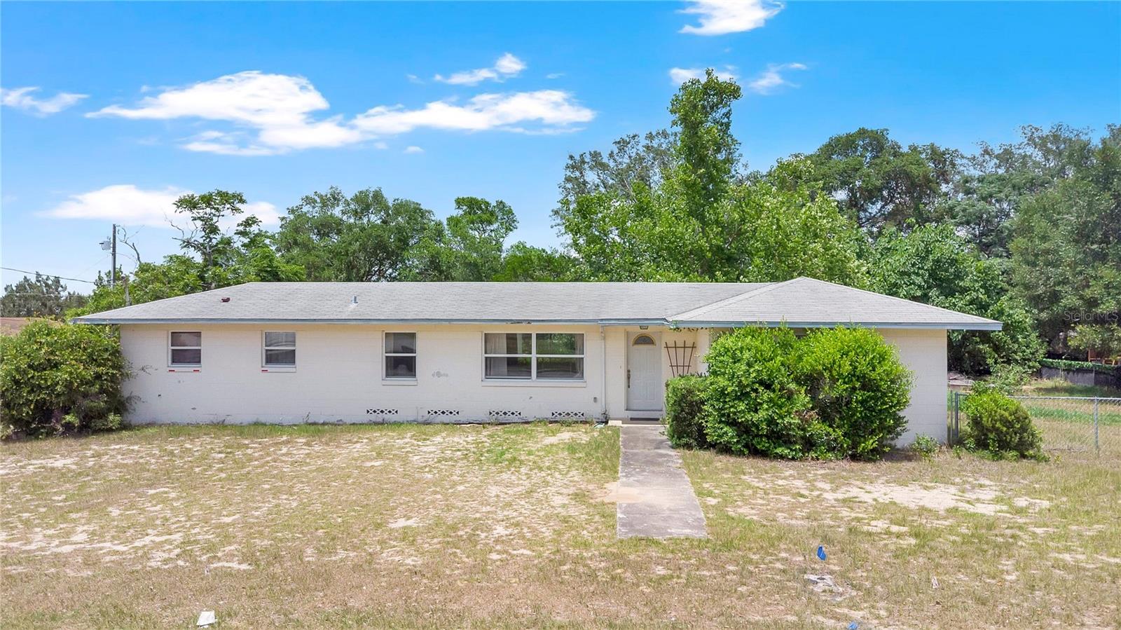 Investor opportunity on a double lot in Eustis with incredible upside potential. This 3 bedroom, 2 bathroom block home offers 1,232 square feet of living area, covered patio areas, and a massive detached garage/workshop that stands out as one of the most unique features of the property.
The spacious detached garage/workshop features high ceilings along with water and electric already connected, creating exceptional flexibility for workshop space, storage, hobby use, or future conversion possibilities. With no HOA restrictions, the property offers multiple opportunities for expansion, additional living space, or possible future income producing potential subject to buyer verification with the city and county.
Covered patio spaces create additional outdoor living and entertaining areas while the double lot provides added flexibility and future possibilities.
Home needs renovation and repairs including bathroom flooring/subfloor repair due to prior water damage. An additional bathroom area exists within the converted portion of the home but is not included in the county's official bathroom count. Roof is aged and will more than likely require replacement for insurance purposes.
This fixer upper is an excellent opportunity for investors, contractors, or buyers looking to renovate, expand possibilities, and build equity. Potential opportunity to create additional living space that could produce income while occupying the main home, subject to buyer verification with local zoning and permitting requirements.