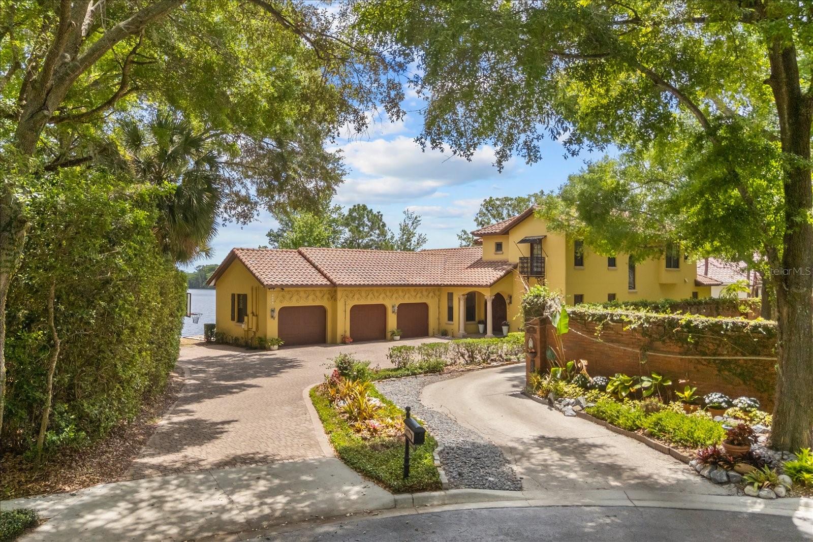 Modern, mediterranean lakefront residence in one of Maitland’s most desirable GATED communities, positioned on a private cul-de-sac atop a natural rise. Set on over 1.3 acres with approximately 179 feet of frontage on Lake Jackson (ski lake), the property offers a rare combination of elevation, privacy and expansive water views in a central Maitland location with quick access to I-4, downtown Maitland and Park Avenue, Winter Park. Lake Colony Estates is conveniently located across the street from  Orangewood School. The home was custom built by Keith Groninger, a 10-time Parade of Homes winner.

A tree-lined drive leads to a paved driveway and a welcoming entry with imported hand-crafted 8-foot wood doors and tile roof. Inside, the foyer opens to a dramatic great room with 20-foot cathedral ceilings, clerestory windows and a floor-to-ceiling wood burning fireplace, butlers pantry and wet bar. The home has been refreshed with white interior paint, enhancing the natural light and giving the interiors a timeless backdrop.

The gourmet kitchen is designed for both function and gathering, featuring 3cm granite countertops, a large island, 5-burner gas cooktop with custom stone and mortar arch detail, tumbled marble backsplash and vaulted ceilings with exposed wood beams sourced from Pennsylvania. Expansive lake-facing pocketing windows frame Lake Jackson and open the chef’s kitchen to the screened porch for effortless outdoor dining and entertaining

The first-floor primary suite features engineered hardwood floors, direct access to the outdoor pool and a spacious bath finished in tumbled marble with a soaking tub, dual vanities and walk-in shower. A large custom walk-in closet provides generous storage.

Upstairs, three oversized bedrooms each offer ensuite baths and a large bonus room overlooking the lake.

Outdoor living is centered around the covered, screened porch, lakefront setting and gated pool. The private and expansive lawn -179 feet of shoreline, complemented by a private boathouse (newer lift) with direct access to Lake Jackson for boating, skiing, jet skis, canoes, paddleboards and more! Also, enjoy sunrise views over Lake Jackson!

Additional features include two new ACs, oversized three-car garage, amazing storage and closet spaces, mature and new landscaping and carefully maintained architectural detailing throughout. American Home Shield home warranty offered with full price or higher offer for American Home Shield. Four point, roof certification and wind mitigation reports will be provided by the sellers.