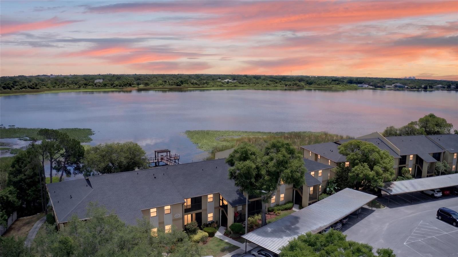 Welcome to waterfront living on beautiful Lake Seminole in the gated community of Bella Vista! This freshly painted 2-bedroom, 2-bath ground-floor condo offers the perfect blend of comfort, convenience, and scenic lakefront views. Step out your back door to the community dock where you can fish, relax on a bench overlooking the water, or simply enjoy the peaceful setting.

Inside, the open and airy split-bedroom floor plan features tile flooring, crown molding, and two screened lanais that create the perfect indoor-outdoor lifestyle. The spacious living room and kitchen both enjoy tranquil lake views, while the kitchen opens seamlessly to the living area and adjacent dining space. A sliding glass door from the dining area leads to the front screened lanai, complete with a convenient storage closet.

The primary suite is a private retreat featuring an ensuite bathroom, walk-in closet, and a sliding glass door opening to the rear screened lanai with direct lake and dock views. The second bedroom also offers private access to the front screened lanai through its own sliding glass door.

Additional highlights include an inside utility room, with a washer and dryer, and an assigned covered carport space to help keep your vehicle cool and protected.

Bella Vista residents enjoy an impressive array of resort-style amenities, including a heated pool, hot tub, clubhouse, fitness center, gas grills (including one on the dock), scenic walking paths along the lake, a fishing pier, canoe and kayak storage, and more. Experience relaxed Florida waterfront living at its finest!