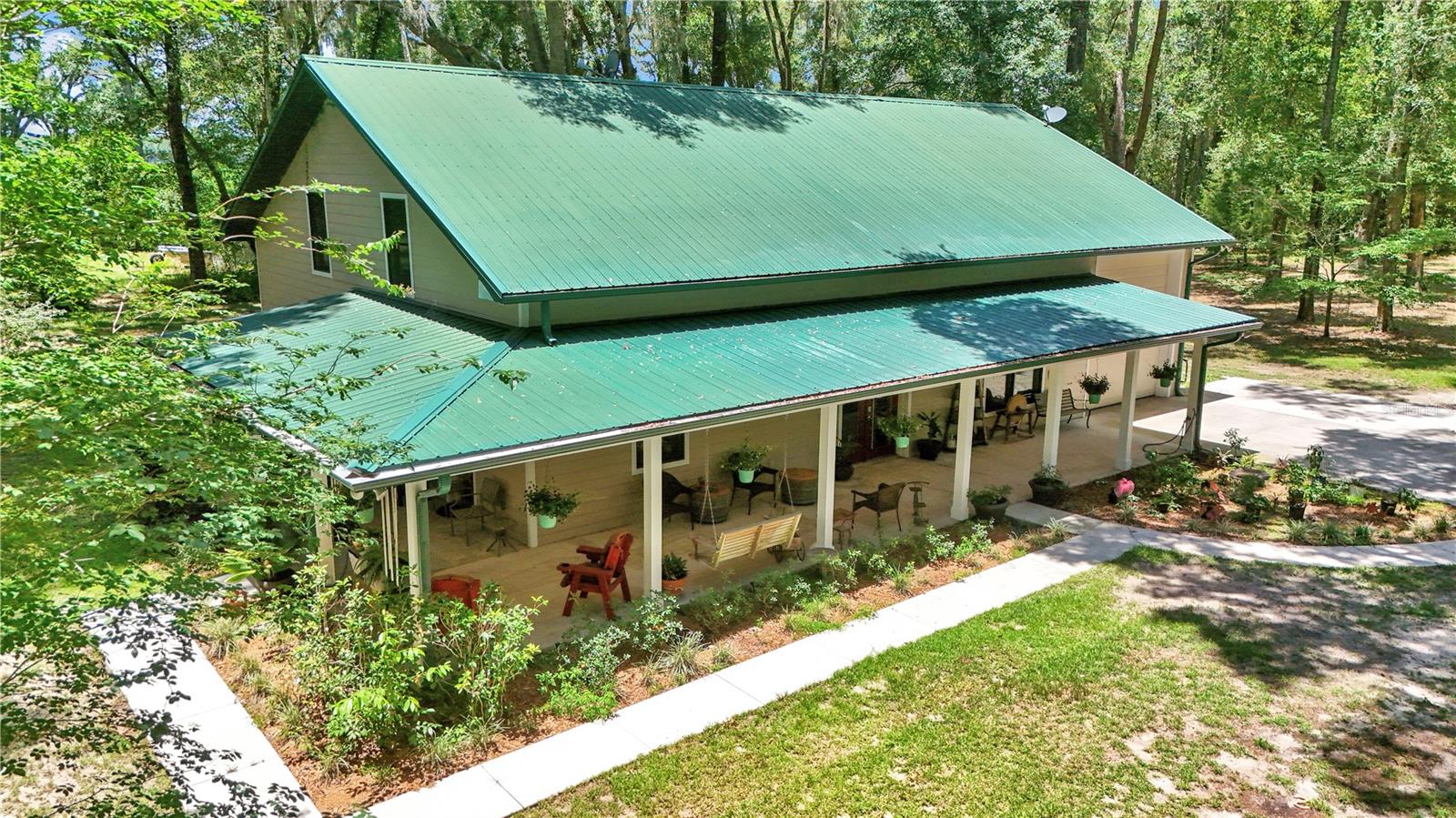 Escape to Your Own Private Country Retreat. Experience the best of peaceful rural living in this charming 3 bedroom, 2-bath home nestled on more than 6.5 private acres. Surrounded by mature trees and abundant wildlife, you'll enjoy visits from deer, wild turkey, quail, and rabbits, creating a serene setting you'll love coming home to. 
Inside, the open-concept design seamlessly connects the kitchen, dining area, and great room, providing an ideal space for both everyday living and entertaining. Hard-surface flooring extends throughout the home, and the thoughtfully designed triple-split bedroom layout offers added privacy, with two bedrooms on the main level and a private en suite retreat on the second level (featuring extra deep treads and short risers, this staircase is almost effortless for little ones, and uniquely comfortable for older adults. It is truly welcoming for the entire family and guests alike).
Step outside to the expansive wraparound porch and outdoor kitchen (including, gas grill, cooktop, electrical power, sink with hot & cold water).  Relax, entertain entertain a large number of guests day or night, or simply enjoy the peaceful surroundings while taking in the sights and sounds of nature.  The huge 40' drive through garage has 12' x12' insulated doors on both the front and rear. Your RV'ing guests will enjoy full hookups (30 amp power plus water and septic for 2 RV's at once). The home was constructed using Insulated Concrete Forms (ICF), hardie Board siding, and topped with a metal roof. This home is designed for lasting quality, energy efficiency and low operational costs (Utility bill averages $264/mo. and insurance $155/mo). No HOA and no HOA Fee.
Conveniently located about 7 miles from High Springs, 7 miles from Newberry, 10 miles from Alachua, and 18 miles from Gainesville, you'll enjoy the tranquility of country living while remaining close to shopping, dining, schools, and everyday conveniences. Outdoor enthusiasts will appreciate the easy access to North Florida's renowned springs, rivers, and parks, offering endless opportunities for kayaking, paddleboarding, swimming, fishing, boating and exploring the area's natural beauty.
If you've been searching for a private retreat that combines space, comfort, efficiency, and easy access to nearby amenities, this exceptional property is ready to welcome you home. Ask for video.