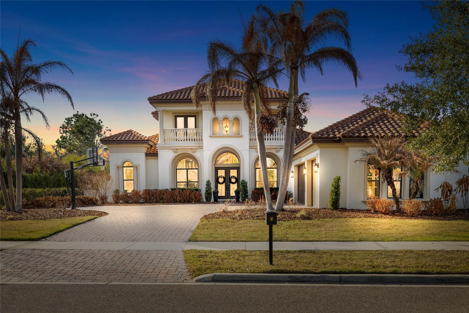 EXTRAORDINARY LUXURY HOME! ARTHUR RUTENBERG BUILT! Located in the gated section of Chapman Crossing in the desirable FishHawk Ranch community, this Mediterranean style home includes 4 bedrooms, 4 and a half bathrooms, side entry 3-car garage, and sits on an oversized lot with brick driveway pavers and a tiled roof!  Upon entry, an open foyer with a grand staircase awaits, with high ceilings adorned with crown molding and coffered/ tray areas, as well as plantation shutters and timeless wood floors throughout. Near the entryway is a private office, formal dining room, and formal living room with a fireplace, coffered ceiling, and triple sliders with a gorgeous view of the pool to see as soon as you walk inside the home.  The stunning remodeled kitchen features a center island, breakfast bar, 42-in cabinets with crown molding & under cabinetry lighting, Modern GE stainless-steel appliances with a gas-cooktop & built-in oven, walk-in pantry, quartz countertops, and stunning tiled backsplash! There is ample natural light with windows surrounding the dining space, and a family room open to the kitchen, perfect for entertaining guests.  The primary suite is on the first floor and separate from the remaining bedrooms, featuring hardwood floors, tray ceiling, tons of natural light, dual walk-in closets with custom built-ins, and a door leading to the lanai. The remodeled ensuite bathroom is gorgeous, having everything you could dream of, with double vanities, huge tiled walk-in shower, and a separate garden tub. The second bedroom is split on the first floor, ideal for a guest suite, with the remaining bedrooms upstairs both having their own bathrooms and each with a private balcony! Plus, an upstairs bonus room with a large UPSTAIRS BALCONY overlooking the pool. Step outside into your own private oasis, PRIVATE POOL WITH A STONE WATERFALL, covered lanai screened in for comfortable outdoor lounging, and a fenced in yard with plenty of space for endless possibilities. This home has it ALL! The FishHawk Ranch community is FILLED with scenic ponds and trails, resort style amenities, clubhouses, parks and playgrounds, and zoned for Fishhawk Creek Elementary, Randall Middle, and Newsome High School. ALL A-rated schools! Make this wonderful home your own! Call today to schedule a private viewing!