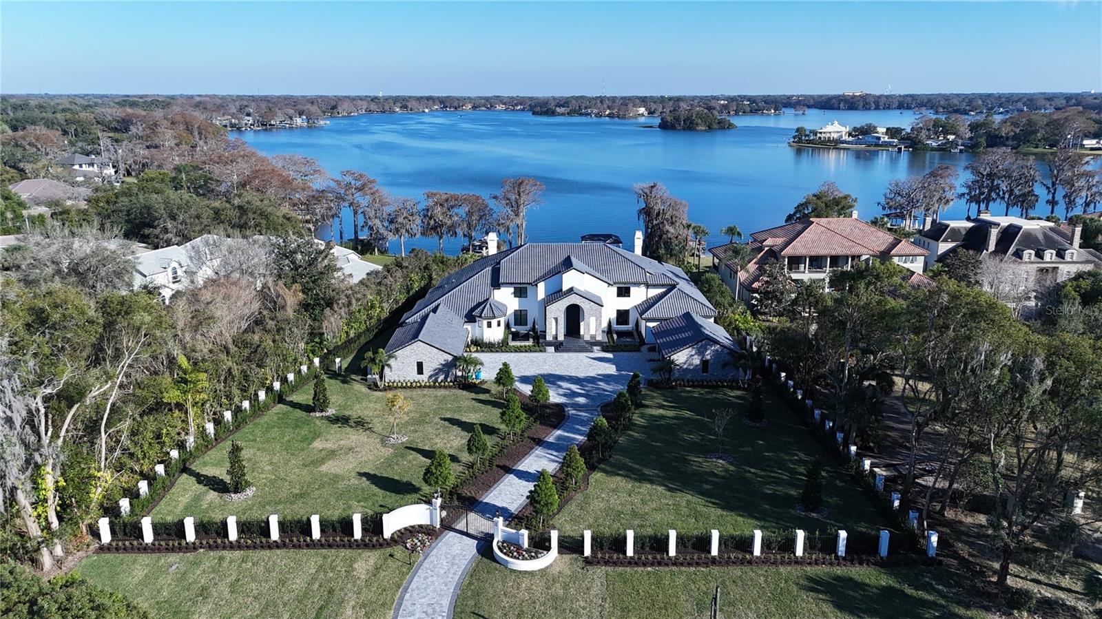 Welcome to Maison Du Lac, nestled within the sought after Winter Park chain of lakes, this magnificent 11,668 sq ft estate presents an unparalleled living experience on 2.73 lush acres. With meticulous attention to detail and an expansive layout, this home offers 5 suites plus an opulent master wing, complete with its own office, sauna, and gym, ensuring privacy and luxury at every turn.

Enter through the 14-foot custom iron front door, a statement piece valued over $50K, to discover a world of refined elegance. The main great room, illuminated by a "luxury hotel" crystal chandelier worth over $100K, sets the tone for an interior professionally designed with custom artwork. State-of-the-art energy-saving windows bathe the space in natural light, highlighting the exquisite craftsmanship and state-of-the-art appliances that adorn the home.

The master wing is a sanctuary of tranquility, featuring a secret safe room within the master bathroom for ultimate privacy. His and hers massive walk-in closets offer lavish conveniences, including a built-in watch winder and a special shoe closet for her, catering to the most discerning tastes.

This estate is an entertainer’s paradise, boasting a summer kitchen, a bar, and entertainment areas designed for hosting memorable gatherings. The brand new, completely rebuilt dock invites leisurely days by the lake, while the 6-car garage accommodates any automotive enthusiast.

This residence combines modern convenience with peace of mind, equipped with a state-of-the-art smart home system and an alarm monitoring system. The privacy gates ensure a secluded retreat, making this home a secure haven of luxury.

Over $3 million in renovations, including a brand new $350K roof and landscaping exceeding $400K, have transformed this estate into a masterpiece of design and comfort. The enormous walk-in butler pantry and professional interior design elevate the home’s functionality and aesthetic appeal.
 
This estate is more than a home; it’s a lifestyle offering, professional interior designed by MAX Home Design crafted for those who seek the ultimate in luxury, privacy, and lakeside living. Welcome to your exclusive retreat on Lake Maitland, where every detail reflects your desire for the extraordinary. Bedroom Closet Type: Walk-in Closet (Primary Bedroom).
