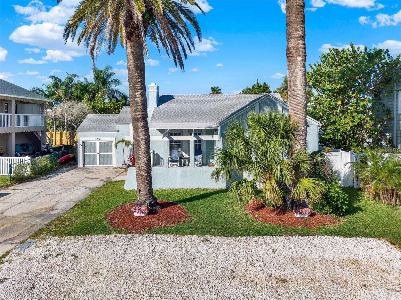FABULOUS, UPDATED HOME JUST 1 BLOCK FROM THE MAGNIFICENT SHORES OF REDINGTON BEACH! This unique move-in ready residence has been meticulously maintained and offers an exceptional combination of charm, comfort, and coastal living. The inviting living room features a cozy wood-burning fireplace and elegant crown molding. The spacious updated kitchen is equipped with beautiful cabinetry, stainless steel appliances, tile backsplash, and a closet pantry. The primary suite includes a WALK-IN CLOSET, French doors leading to the back deck, and an updated primary bath with a dual-sink vanity and tiled walk-in shower. Secondary bedrooms are generously sized and share an updated hall bath with dual-sink vanity and tub/shower combination. Additional flexible living space includes a bonus room, den/office, and a laundry room accessible from the deck. Enjoy the lush, mature landscaping with beautiful palms, a welcoming covered front porch, and a relaxing back deck perfect for entertaining or unwinding after a day at the beach. Additional highlights include a NEW ROOF (2016), HVAC (2025), HURRICANE SHUTTERS, attic storage, and more. An incredible opportunity to own a beautifully updated coastal home just steps from the Gulf!