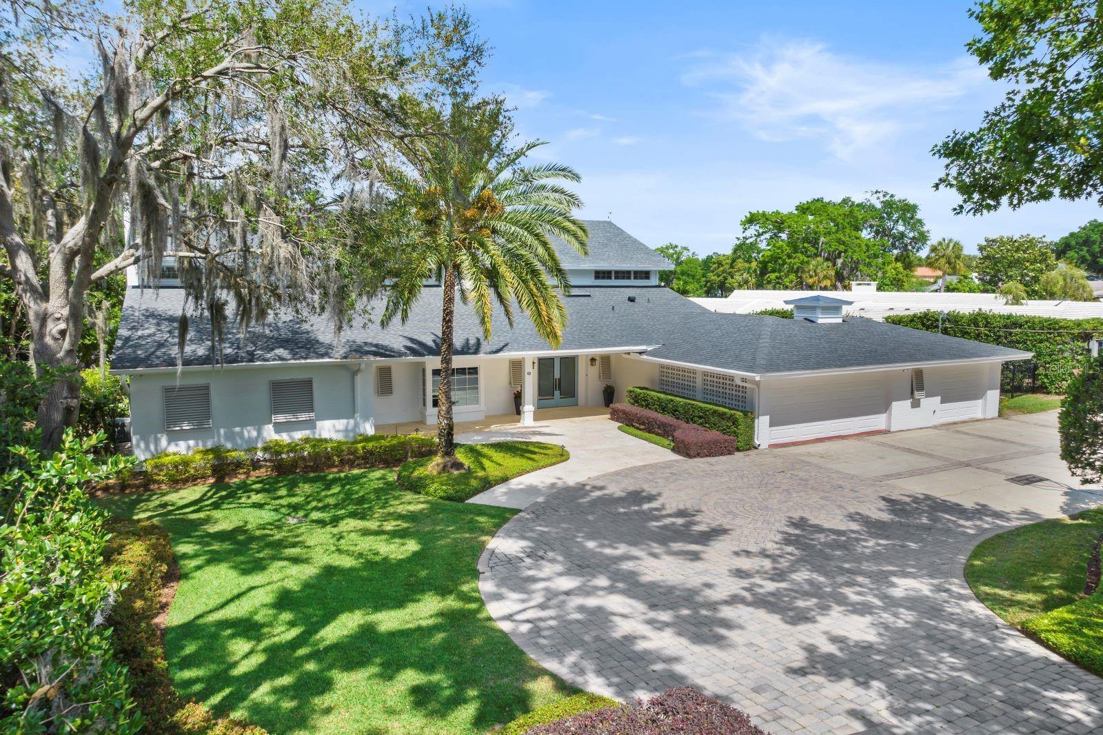 This elegant Winter Park lakefront residence offers luxury lakeside living, situated on the picturesque shores of Lake Osceola. This exquisite home invites you in with a grand circular driveway and meticulous, landscaped grounds, combined with elevated panoramic views from a spacious 3/4 acre lot, with approx. 140 feet on the street and approx.. 110 feet of prime lake frontage.  This property offers a sense of privacy, tranquility and breathtaking views capturing both northern sunrises & sunsets…
Inside, you'll find extensive renovations, over the years, that have elevated the space enhanced with Wolfe-Rizor Interior Design elements…  There is plenty of natural light throughout, with extensive windows, numerous French doors and a thoughtful layout that seamlessly blends indoor and outdoor living spaces. The primary level includes a defined foyer entry, secluded library/home office, kitchen, gathering room, formal living and dining rooms.  The chef’s kitchen is thoughtfully designed and enhanced by an expansive island, commercial grade range, lake side breakfast room, and catering area for creating culinary experiences in hosting family and friends.  The lavish living room includes room for a grand piano and has its own fireplace open to an expansive 30’ long dining room with direct lake views… along with a screened lanai...
The primary suite is conveniently located on the ground floor, offering a private expansive retreat with a sitting area and serene, picturesque lake views. The luxurious primary bathroom provides a spa-like experience including modern fixtures, his/her separate baths, and a generous walk-in closet/dressing room.  The main level also includes a potential 6th bedroom used previously for a caretaker’s quarters tucked away by the garage entry...
The upstairs living areas, include 4 additional bedroom suites (generous sizes) located on the second floor with a couple of bonus/flex rooms and sitting area... When you're not savoring the indoor elegance, step outside to enjoy the lakefront living with entertaining terrace, tropical pool, sprawling lawn with retaining walls, boathouse and majestic cypress, oak & palm trees to enhance the lakefront lifestyle...
Located on private, quiet street with oversized 3-car garage… Note: roof replaced in 2021.  All within walking distance to downtown Winter Park and famed Park Avenue…