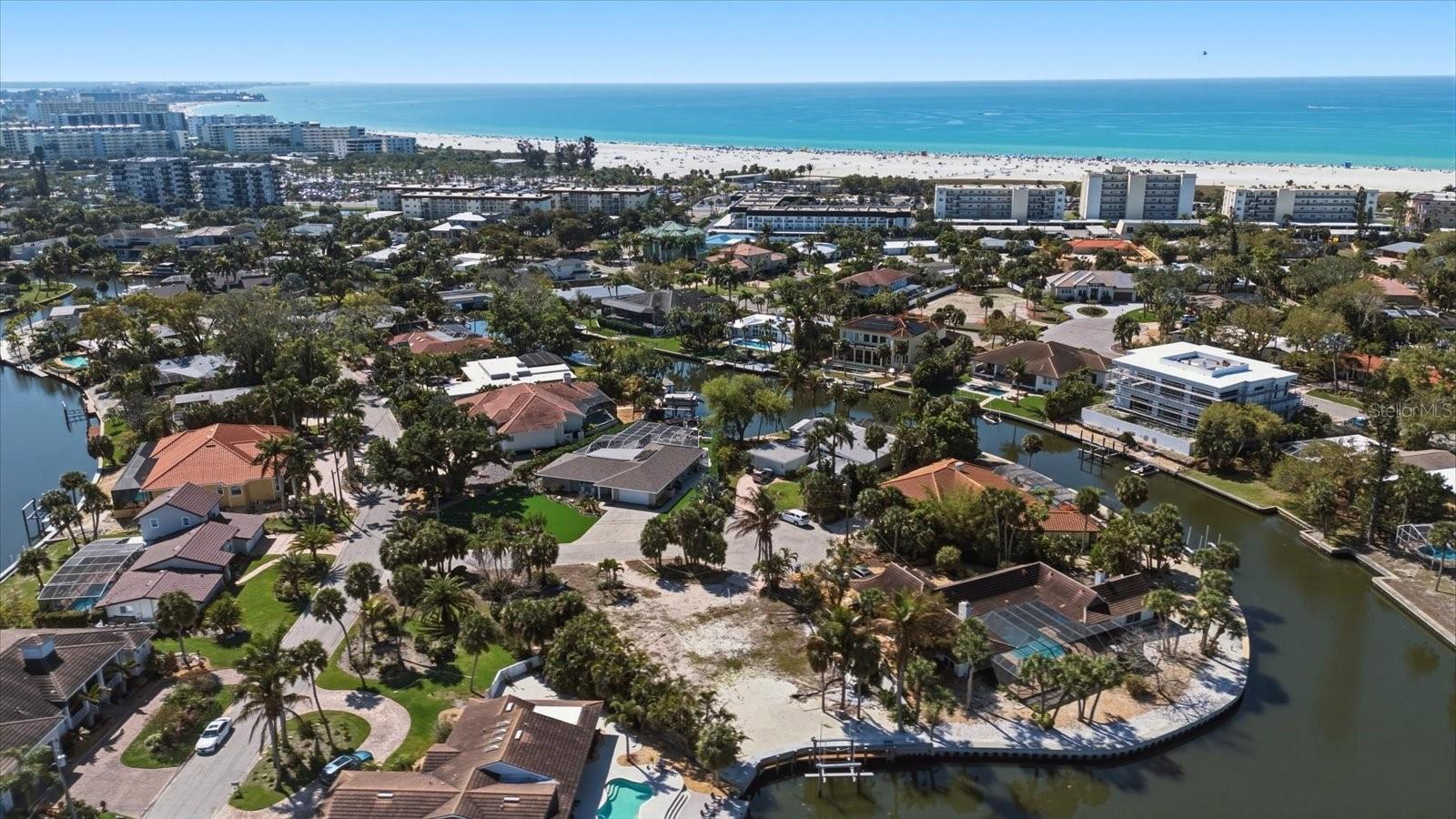 This property checks all the boxes for a fabulous Siesta Key residence: Close to the beach, boat lift in the back, newly raised seawall, and a quiet cul-de-sac. This exceptional waterfront homesite sits in the heart of Siesta Key, one of Florida’s most sought-after coastal destinations. It offers a rare opportunity to build your custom dream home in a serene, prestigious setting where world-class beach access, effortless boating, and exceptional privacy come together perfectly. Nestled on a quiet, no-through-traffic cul-de-sac in the exclusive Siesta Isles enclave, the property enjoys a coveted island-within-an-island feel that delivers tranquility while remaining conveniently located. Just a 5-minute walk or drive away lies world-famous Siesta Key Beach with its renowned powdery quartz sand. Boating enthusiasts will love the direct deep-water access, complete with a private dock and a recently updated (2022) 10,000-pound boat lift. From here, you can cruise easily into the Intracoastal Waterway and the Gulf of Mexico, passing only one bridge at Midnight Pass. The lot features a substantially raised seawall recently elevated an additional 24 inches to an approximate elevation of 5-feet, which is significantly higher than most nearby seawalls. This provides enhanced protection and peace of mind for the new owner. Additional waterfront amenities include concrete steps, a spacious deck, and a convenient water access ladder. A capped freshwater irrigation well is also in place for easy landscaping maintenance. This build-ready property comes with submitted architectural plans for a stunning nearly 4,000 square foot 4-bedroom, 4-bath custom home featuring an impressive master suite, private elevator, and pool. Buyers can choose to use these existing plans and continue working with the current architect, or create something entirely their own. The generous lot offers approximately over 15,000 square feet (per architectural calculations), providing ample space for your vision. You’ll also enjoy convenient proximity to world-class shopping, dining, and cultural attractions in nearby Sarasota.This is a rare blend of luxury, lifestyle, and long-term value. Build your dream coastal retreat where every day feels like a vacation — in one of the most desirable waterfront locations on Siesta Key.