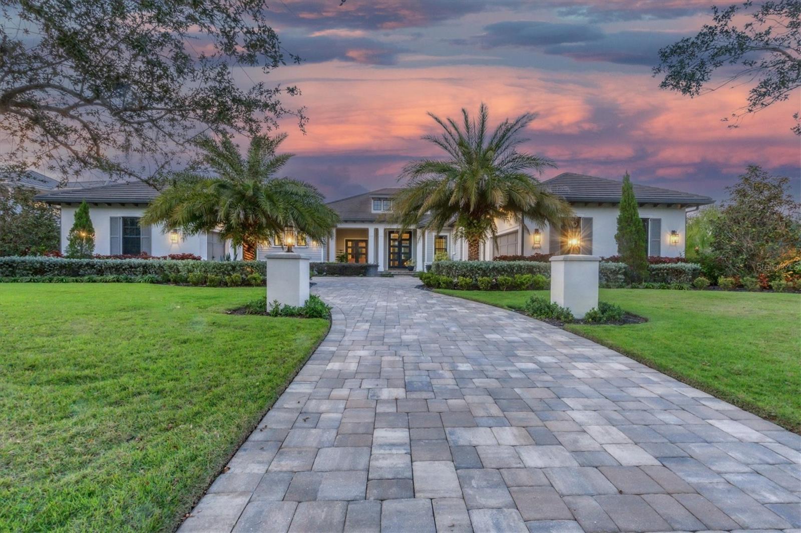 FULL GOLF MEMBERSHIP to Lakewood Ranch Golf & Country Club is available so that you can immediately move to the top of the 3-year wait list!  Conveniently located within the prestigious Lake Club of Lakewood Ranch, is this stunning custom 2019 Lee Wetherington residence on a spacious and rarely available 0.8 acre lot.  Enjoy the meticulously landscaped beds, large front lawn, plus a separate side garden with fenced-in dog run. You are welcomed home to an inviting front porch with Hardiplank siding and into a luxurious foyer through double iron doors.  Sparkling lake views shine from the moment you walk in along with an open floor plan and custom design details including wood-look porcelain tile flooring, beamed and coffered ceilings, contemporary stylings, extra doors and windows for natural light and designer light fixtures.  The impressive great room showcases a cozy fireplace and feature wall, custom A/V system, plus open flow between the dining room and kitchen.  Through pocketing impact sliding glass doors, you can admire the expanded lanai and lake views, still visible even when the sliders are closed through additional aquarium windows.  The private lanai will be your favorite space in the home with travertine stone pavers, colonnade screen enclosure, custom tray ceiling over the entertaining areas, custom firepit, and elegant outdoor kitchen with stainless steel grill.  Soak up the sun in the custom saltwater pool with raised spill-edge spa, gas heater, large sunshelf, and lake views.  The chef’s kitchen features functionality and contemporary design featuring a central island with counter-height seating, stone counters, plentiful cabinetry, cleverly hidden walk-in pantry, subway tile backsplash, shiplap ceiling, and stainless-steel appliance suite including Wolf range and SubZero refrigerator.  The study is conveniently located toward the primary wing and includes a vaulted ceiling, French doors to the lanai and two built-in closets.  The primary suite will be your tranquil escape with lake views, French doors to the lanai and dual walk-in closets with custom shelving and barn-style door. The ultimate “wow” factor is found in the primary bathroom with visual checkerboard porcelain tile, floral feature wall, free-standing modern tub, dual sinks on a long vanity with two storage towers and a tile feature wall, LED vanity mirrors, and a Roman walk-in shower with multiple shower heads.  Guests will enjoy their own cozy accommodations, in one of two guest bedrooms with en-suite bathrooms.  For even more functionality, there is a large bonus room with disappearing corner glass sliders, that can be used as a media room, game room, additional guest space with a nearby powder bathroom or a second office.  Rounding out this impressive estate is a large laundry room with wall-to-wall counters and storage and a side-loading 2-car garage with workshop and storage, plus an additional oversized 1-car garage with private entrance.  Peace of mind is secured with impact windows and sliding glass doors, plus whole-house surge protector.  The Lake Club is a private gated community including a grande clubhouse, restaurant, pool, tennis, pickleball, playground, basketball, Linear Park, fitness center, and interlinking lakes for kayaking or fishing.  Lakewood Ranch is the top multi-generational community in the country for five years in a row with award-winning shopping, dining, A-rated schools, parks and nearby beaches. Bedroom Closet Type: Walk-in Closet (Primary Bedroom).