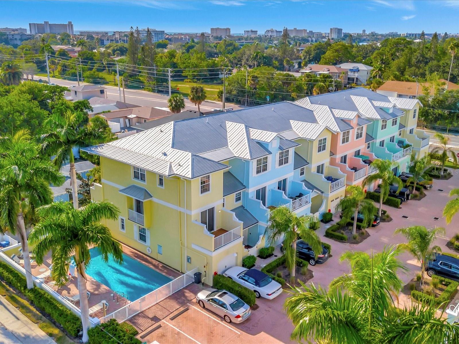Indulge in the island lifestyle with this exquisite Key West-style townhome, walking distance from the crystal sand beaches of Siesta Key. Bathed in natural light, this end-unit residence is a blend of luxury and coastal charm. Boasting 3 bedrooms and 2.5 bathrooms, this home is a testament to thoughtful design and is being sold turn-key furnished. The coveted private one-car garage, impact glass windows/sliders, and access to the community pool enhance its allure. A series of outdoor spaces, including a covered patio, two expansive terraces, and a Juliet balcony, provide idyllic settings for sunsets and tropical breezes. Inside, a masterfully designed split floor plan balances privacy with an open living concept. The first floor hosts guest bedrooms and a full bathroom, while the expansive primary suite claims the entire top floor, offering serenity and a lavish 5-piece bathroom. Entertaining is effortless in the main living area, featuring ceramic tile, a half bath, and seamless indoor-outdoor living. The kitchen, adorned with granite countertops and white cabinets, exudes style and functionality. Live the island life about half a mile from Siesta Key beach access and South Siesta's vibrant shopping, dining and marina. Immaculate condition meets rental potential, with a projected income over $90,000, monthly rentals allowed and no flood insurance required! Location is paramount, and this townhome is strategically positioned to embrace the best of Sarasota and Siesta Key. Your piece of paradise awaits—don't let this gem slip away.