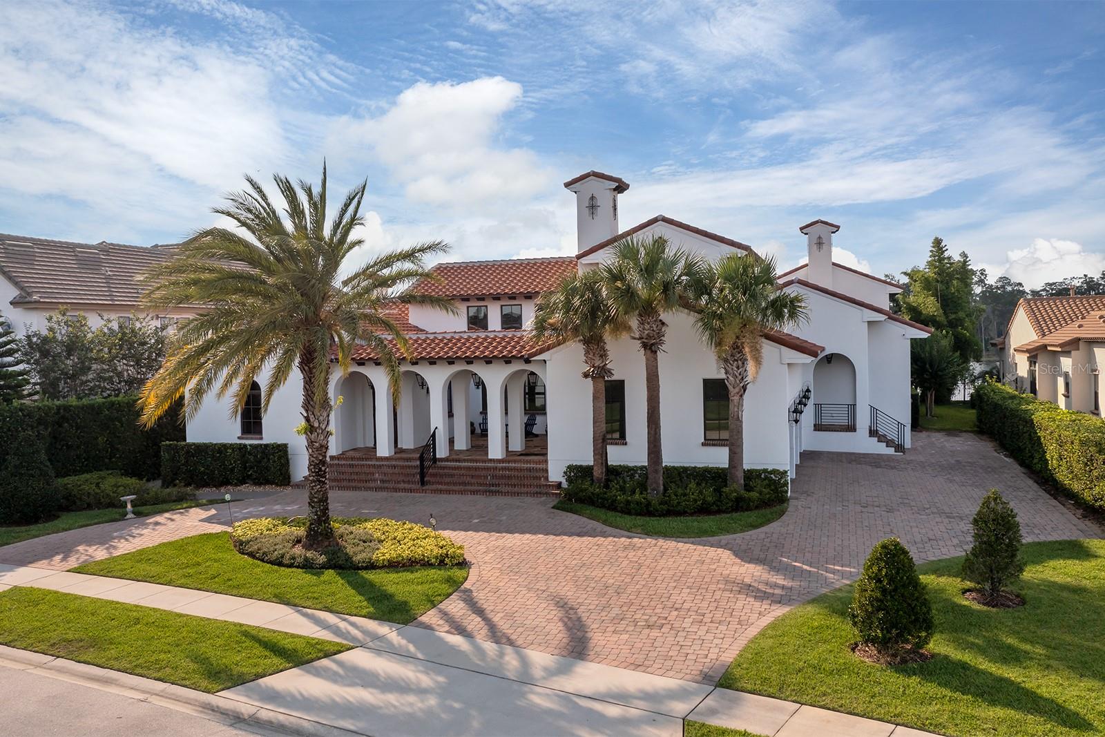 Come settle in at this tranquil custom lakefront home on the shores of the Butler Chain of Lakes in Dr. Phillips. Offering unsurpassed elegance and distinction, this home is a meticulous combination of living and entertaining. Located in the prestigious 24-hour guard gated community of Emerson Pointe in the Bay Hill community, this luxurious home offers impressive views and gorgeous sunsets overlooking Lake Chase. Warm colors, rich details and authentic charm and character reflect an eclectic mix of Mission and European architecture with modern luxuries. Displaying influences of timeless beauty with high ceilings and an extensive array of woodwork, including exposed beams, timber trusses, barrel ceiling and more, are some of the distinct features found throughout the living areas. Entering the home, you are embraced by arches outside and inside, leading to nine sets of 10-foot French doors that overlook an artfully crafted central courtyard. The stunning fountain and surrounding landscaping were designed to enhance the natural blending of indoors and outdoors and provide sunlight into the center of the house. The front guest bedroom serves as an attached casita with a full bedroom, bath and living area with its own entrance but is also connected to the main living area. The four bedrooms are located on the main floor along with six baths, the living room, kitchen, family room, dining room, laundry and office. Downstairs offers a gym, movie theater, full bath, storage closet and game room with a custom Sapele bar. Another amazing amenity is the studio above the three-car garage, a place for hobbies or storage. Go down the hallway to the main area of the home. The view is spectacularly captured by 32 feet of 10-foot-high sliding glass pocket doors overlooking the panoramic lake. The large island offers a large amount of space to entertain and the Thermador appliances are a welcome feature of the exceptional kitchen. Continue to the dining room, office and primary bedroom and enjoy the lake view as you go past the wall of fixed and operating French doors. The wood-covered patio ceiling and bar permit you to relax by lounging under the shade. Or sit on the open deck by the outdoor fireplace and pool as you watch the sunsets and fireworks. The summer kitchen has been outfitted with a brand new 36-inch DCS grill and is just waiting on its new grill master. The opportunity to unwind continues from the infinity pool and spa to the dock. An extension of the indoor living space, the boat dock with wood ceilings has a boat lift and one double ski lift, enabling you to enjoy the activities of jet skiing, boating, paddle boarding, wakeboarding or kayaking along the 13 lakes of the Butler Chain. Ideally located in Dr. Phillips, this home boasts a remarkable location with proximity to Arnold Palmer Golf Course, Restaurant Row, Orlando International Airport and more. This is your chance to own a rare lakefront home with wonderful lakefront views.