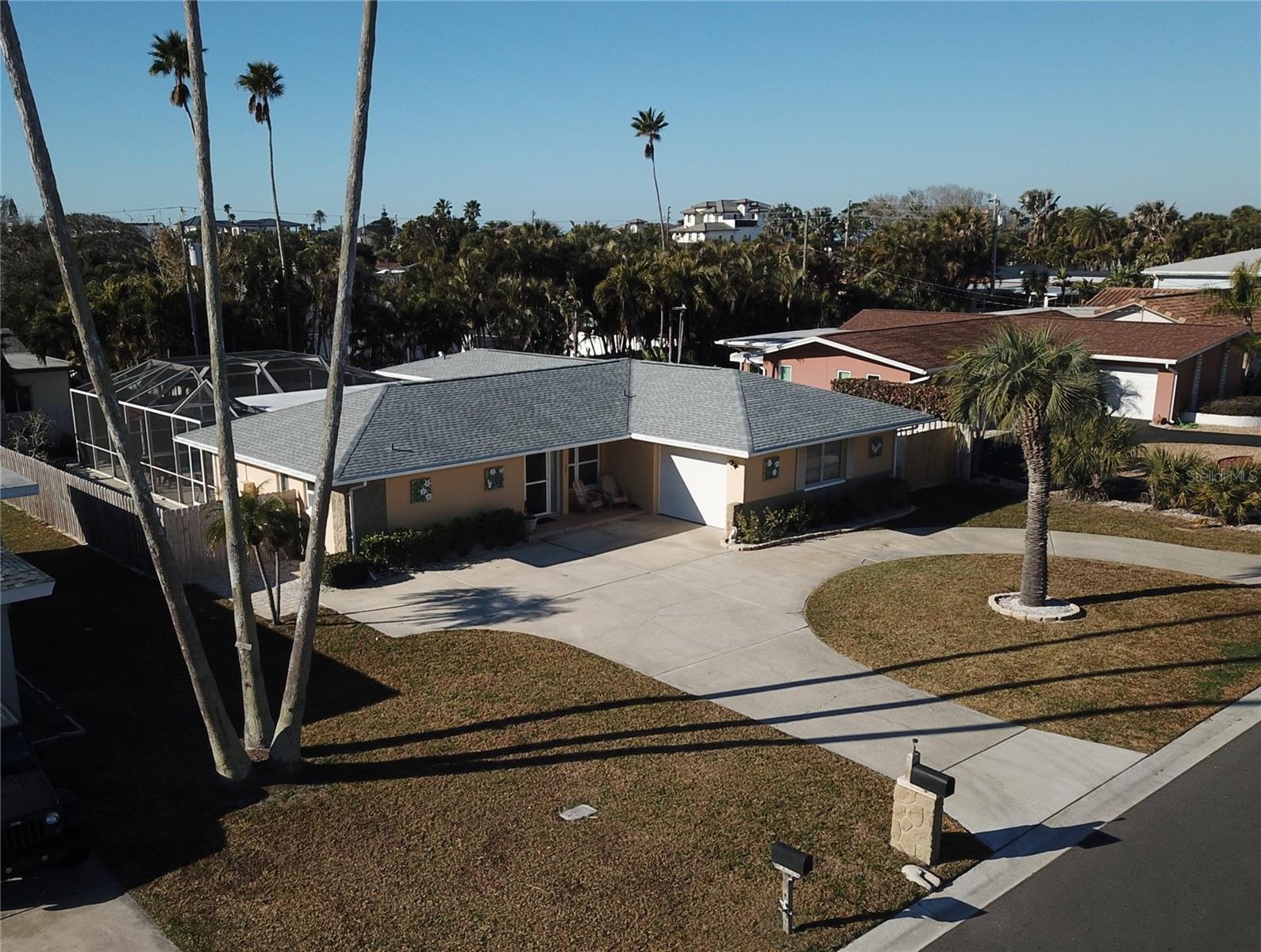 This spacious, light-and-airy split-plan pool home with 3 bedrooms and 3.5 bathrooms sits about 320 yards from resident-only beach parking. The open layout includes a remodeled kitchen with newer cabinets, appliances, stone counters, and a breakfast bar; remodeled bathrooms; a south-facing sunroom overlooking the pool and spa; a newer built-on mother-in-law suite with a bathroom and mini kitchen; a generous master suite; a third bedroom and adjoining bathroom; luxury vinyl plank flooring throughout; interior laundry; an enclosed heated pool, spa, patio, and bathroom; and a new roof (Feb 2026). The oversized air-conditioned single-car garage has a workshop area with a sink. An additional air-conditioned storage area can be accessed from the gated parking area on the home's west side. The home has a circular drive. See the video virtual tour.