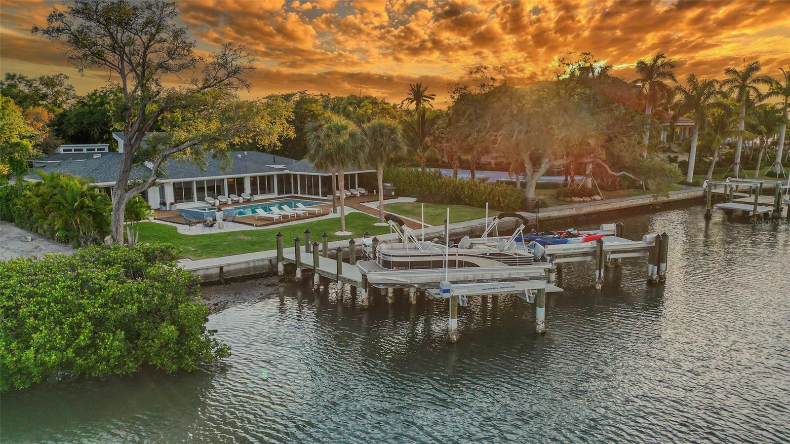 Outstanding opportunity in the Harbor Acres Estate Section, one of the most coveted neighborhoods in Sarasota. Situated on a Sprawling .69-acre lot with 105 feet of waterfront on the bay, this home is set back from the street and surrounded by mature tropical landscaping, providing ample privacy and a serene setting. Accessed through a private gated driveway, the property welcomes you with a paver driveway and motor court plus a 3-car-side entry garage. Renovated in 2015, the 4982 square foot space includes the main house with 4 bedrooms and 3.5 bathrooms and  a separate guest suite with an oversized bedroom, bathroom, living room and a private entry. Additionally, there is a guest suite with an oversized bedroom, bathroom, living room and a private entry. Upon entering the front door, you are greeted with water views through the walls of windows, natural light floods the main living space with vaulted ceilings and skylights. The kitchen features a natural gas Wolf range, an Italian marble Island with seating, custom cabinetry, and a large hidden pantry. Other notable details include the Mahogany hardwood floors throughout, the open layout with a split bedroom floor plan, and an aquarium glass dining room with tongue and groove ceilings. The generously sized owner's suite has beautiful views of the water and private access to the backyard. The outdoor living space is thoughtfully designed with Brazilian IPE tile decking surrounding the pool and spa, providing ample room for entertaining. Stroll down Hillview Drive three blocks to the shops and restaurants of Southside Village or take an easy drive to the downtown Sarasota Bayfront and the world-class beaches of Lido and Siesta Key.