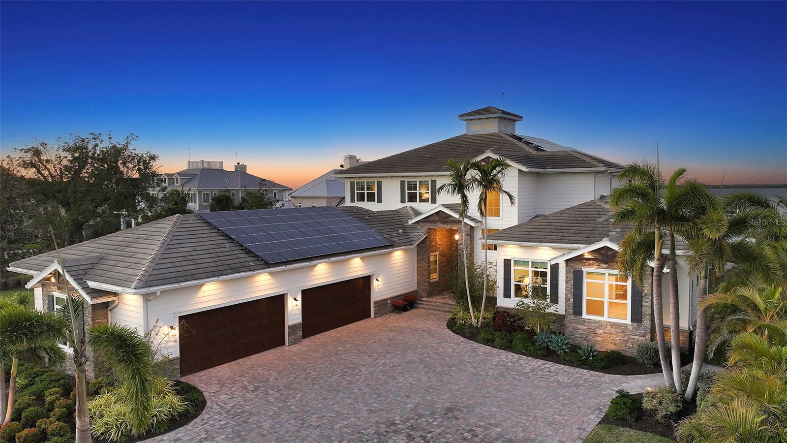 Embodying the pinnacle of storm-resilient luxury, this exceptional waterfront estate is thoughtfully fortified with premier safety features. Solar panels paired with backup batteries seamlessly operate the first floor of the main home and fully power the guest house during outages. A 500-gallon buried propane tank, concrete roof tiles, hurricane impact glass throughout, and a full suite of electronic and metal hurricane shutters — including five remote-controlled systems enclosing the main floor covered lanai and second-floor remote screens — offer peace of mind through every season.
A true boater’s paradise on the Manatee River, this modern custom estate offers direct access to the Gulf of Mexico, with idyllic destinations like Anna Maria Island, Longboat Key, Sarasota, and St. Petersburg just moments away by water. Built in 2020 and spanning 6,621 square feet, the residence combines architectural elegance with cutting-edge smart home technology for effortless living. Situated on elevated, flood-free ground, the home has weathered all storms unscathed, according to the owner.
The main residence and 1,344-square-foot guest home together feature a seven-car garage, ideal for collectors or additional storage. Inside, five bedrooms, five full and two half baths are thoughtfully designed with premium finishes, including engineered hardwood flooring and hurricane-rated materials. The primary suite is a serene retreat, boasting a luxurious steam shower with 13 spray heads, soaking tub, towel warmers, and travertine tile. A gourmet kitchen is equipped with Wolf, Sub-Zero, and Bosch appliances, dual islands, and an expansive walk-in pantry with a built-in Sub-Zero freezer.
Designed for grand entertaining, the living room features coffered ceilings, a gas fireplace, and custom cabinetry, while the expansive lanai redefines outdoor living. Nearly 3,800 square feet of screened space includes a bespoke outdoor kitchen, two-sided fireplace, saltwater pool with spa and sun shelf, and a poolside half bath—all secured by remote hurricane shutters. The guest home offers two bedrooms, a luxurious kitchen, impact glass, and a private balcony.
Additional features include an electronic gated entry, lightning and surge protection, cement roof shingles, and a solar-powered system with four backup batteries. Boating enthusiasts will appreciate the five-foot TREX dock with a 16,000-pound boat lift, a 4,500-pound personal craft lift, and a powered utility shed. A private weather station provides real-time monitoring. Located within walking distance of De Soto National Memorial Park, this one-of-a-kind estate offers an unmatched lifestyle of safety, sophistication, and waterfront serenity.