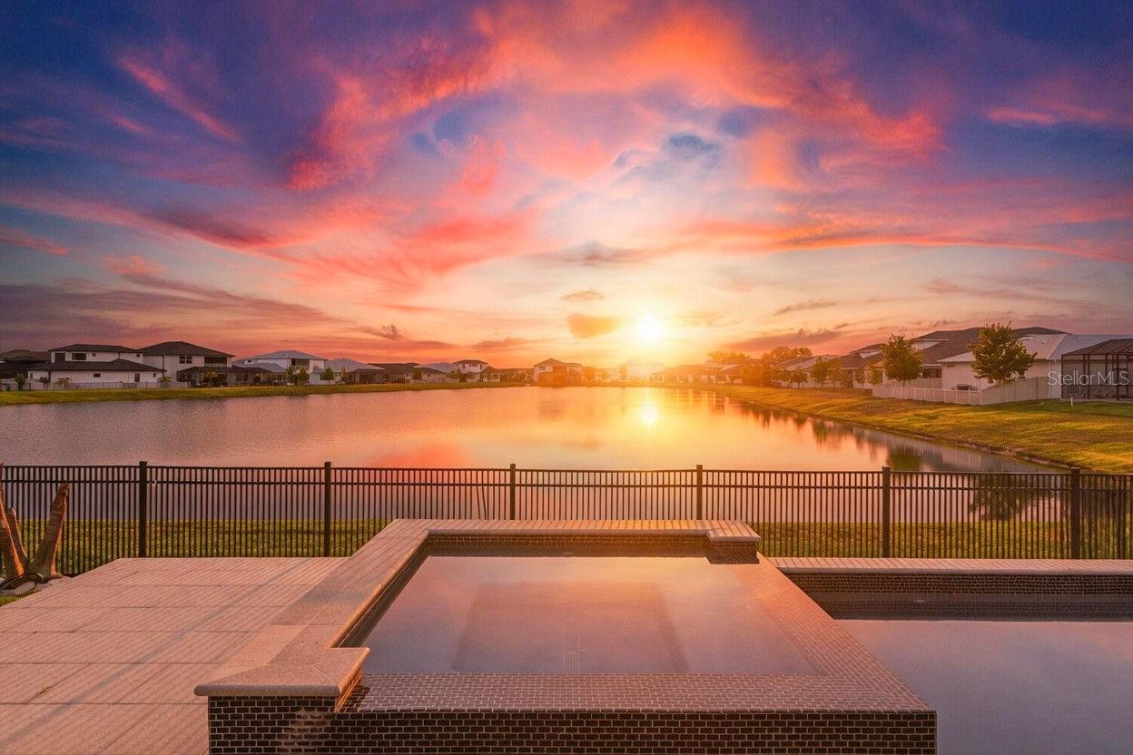 Premier living in the highly sought-after Epperson Lagoon community featuring 4 bedrooms, a private office, 3.5 bathrooms, spacious loft, 3-car garage, and a fabulous pool overlooking a serene pond. Thoughtfully built by Biscayne Homes in 2023, this beautifully designed residence combines upscale finishes with comfortable everyday living. As you enter the home, you'll be drawn to the grand entrance and view to the gorgeous pool indoor/ outdoor living space overlooking the pond. The open layout features a spacious great room connected to a designer kitchen complete with premium appliances, sleek cabinetry, abundant counter space, and a custom walk-in pantry with built-in shelving. The first-floor primary suite offers tray ceilings, a spa-inspired bathroom, and dual custom walk-in closets, while an additional downstairs bedroom provides a great guest room. Upstairs includes two additional generously sized bedrooms along with a large loft perfect for a gym, media room, playroom, or additional living space. Functional upgrades include a mudroom entry, stylish powder bath, EV charging capability, and a split garage layout with a separate single-car bay ideal for storage or hobbies. The backyard was designed for entertaining with a stunning 2024 custom pool and spa, outdoor kitchen, motorized patio shades, and peaceful pond views creating the perfect private retreat. Epperson is known for the famous Crystal Lagoon with sandy beaches, water sports, golf cart paths, scenic trails, and
resort-style amenities, along with playgrounds, fitness stations, dog parks, and a clubhouse overlooking King Lake. Conveniently located near I-75, top-rated schools including Kirkland Ranch Academy of Innovation, and premier shopping and dining destinations such as Tampa Premium Outlets, The Shops at Wiregrass, and KRATE at The Grove, this exceptional home offers luxury living in one of Wesley Chapel’s most desirable communities.