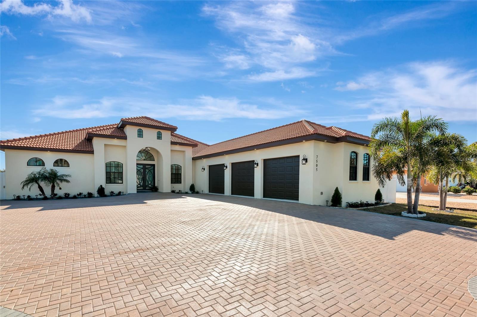 Virtually Staged. A newly built sanctuary of sophistication in Northwest Bradenton, 7505 27th Ave W is a rare fusion of modern elegance, coastal serenity, and expansive living—crafted for those who demand the exceptional. Welcome to your private estate, nestled on over half an acre in one of Bradenton’s most coveted enclaves. Completed in 2023, this 4,941 square-foot architectural masterpiece offers 4 bedrooms, 4.5 baths, an office, and a seamless blend of refined design and everyday comfort. From the moment you arrive, the home’s masonry construction, slick stucco façade, and tile roof evoke timeless grandeur. Step inside to soaring ceilings, sun-drenched interiors, upgraded marble look porcelain floors and a layout that flows effortlessly from formal entertaining spaces to intimate family retreats. The open-concept great room is anchored by a chef’s kitchen with premium finishes, while walls of glass invite the outdoors in. Each bedroom is a private suite, with spa-inspired bathrooms and generous closets. The primary suite is a sanctuary unto itself, offering a spa-inspired bath that exudes indulgence. Step into the oversized walk-in shower, wrapped in floor-to-ceiling upgraded porcelain tile that blends sleek modernity with timeless elegance. Whether you're starting your day or winding down, this expansive shower offers a rejuvenating experience that rivals any five-star retreat. Outside, the 0.63-acre lot provides ample space for a future pool, outdoor kitchen, or garden oasis—limited only by your imagination. An oversized 3 car attached garage ensures convenience for plenty of storage for cars, toys, or an at home gym. Located just minutes from Palma Sola Bay, Anna Maria Island beaches, and the cultural charm of downtown Bradenton. Whether you’re hosting a sunset soirée or enjoying a quiet morning with coffee and coastal breezes, Live expansively. Live exquisitely. Live here!