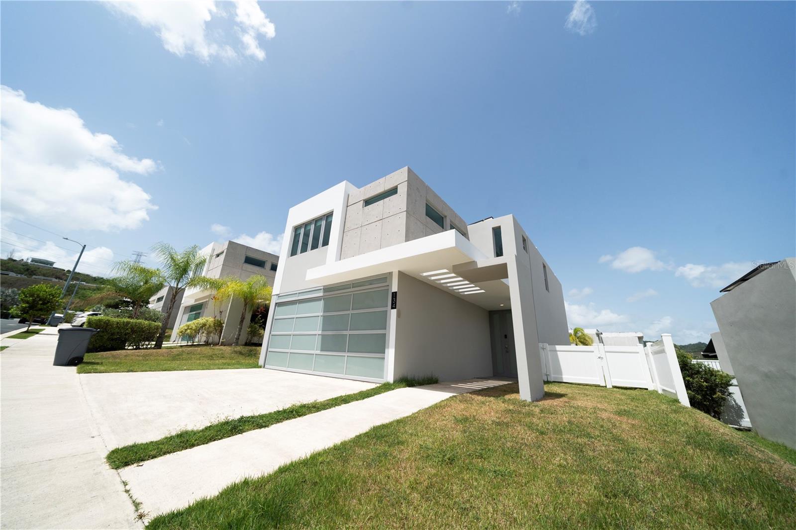Contemporary residence built in 2021 located in the exclusive Montecielo community in Guaynabo. This property features 2,529 square feet of living area on an approximately 3,500 square foot lot, offering 4 bedrooms, 2.5 bathrooms, and garage for two vehicles. Its modern open-concept design connects the living, dining, and kitchen areas, creating a bright and functional layout enhanced by abundant natural light. Additional features include a solar energy system (24 panels and 1 Tesla battery), a fully fenced backyard, and a 500 gallon cistern. Montecielo offers outstanding resort-style amenities including 24/7 controlled access, clubhouse, fitness center, swimming pools, tennis courts, pickleball courts, beach tennis courts, and basketball courts. Conveniently located near top schools, hospitals, and major highways that connect to the San Juan metropolitan area. An exceptional opportunity to own a modern home in one of Guaynabo's most desirable communities.