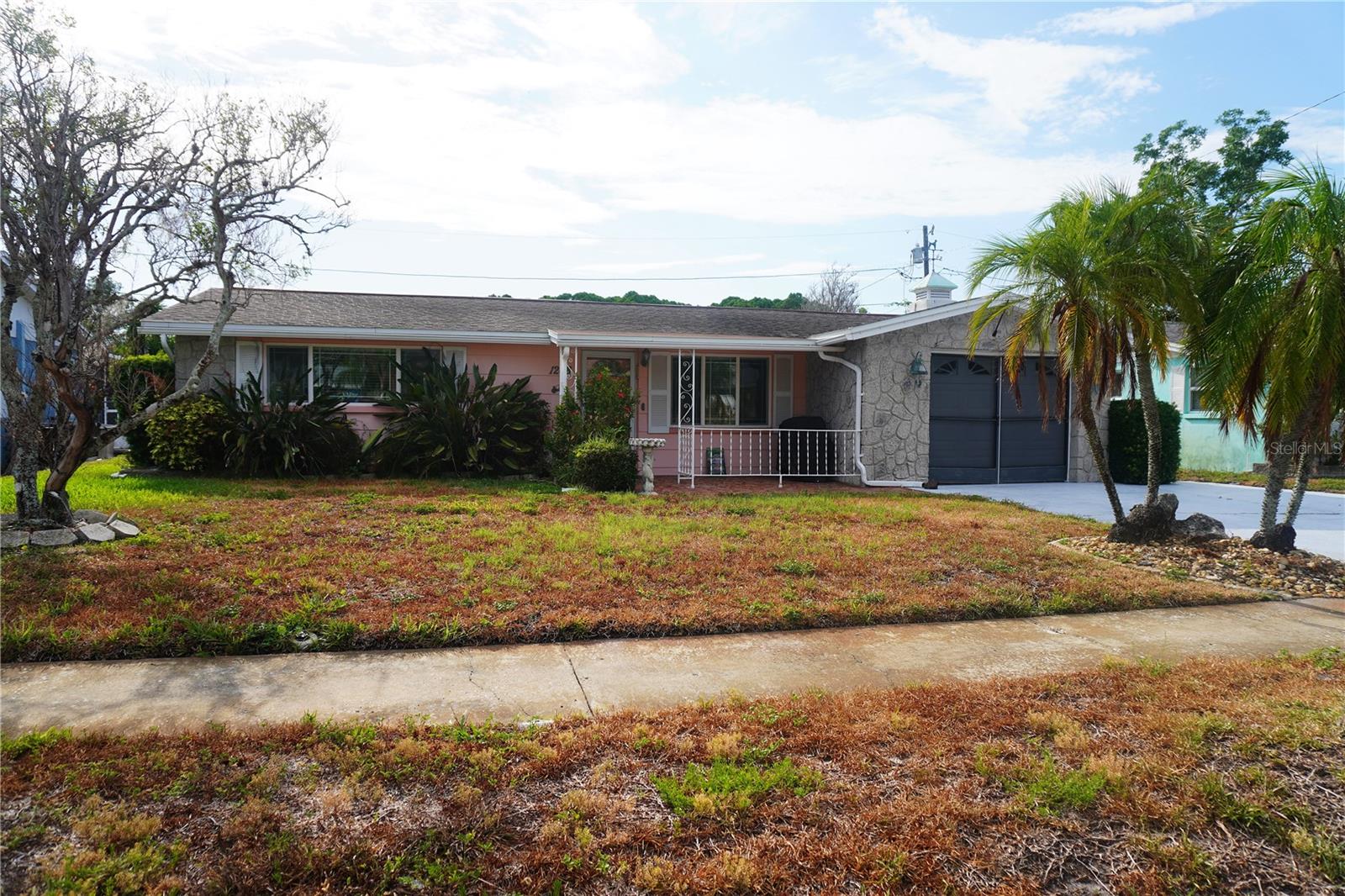 Tucked into the established Forest Hills neighborhood, this 1969 block-built single-family home offers a smart opportunity in the heart of Holiday. Two bedrooms, two full baths, plus a half bath and an attached garage, with an enclosed Florida-style porch made for easy mornings. No flood-zone headaches here.   Close to US-19, Gulf beaches, Tarpon Springs' Sponge Docks, and everyday shopping. Bring your vision and make it yours.