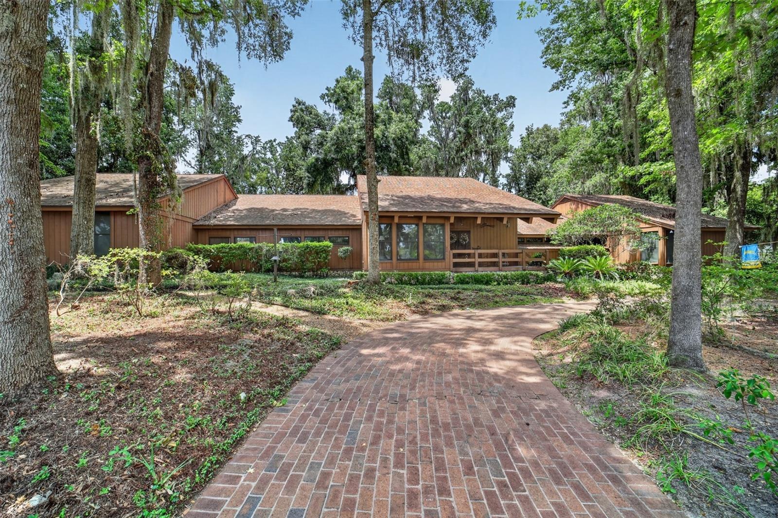 This stunning, one-of-a-kind custom home offers 4,985 square feet of luxurious living space, meticulously built by renowned builder George Barns. Set on a spacious 0.75-acre lot with beautiful landscaping in the SE Woodfields area, this exceptional residence combines timeless craftsmanship with thoughtful design for comfortable, elegant living. Step inside to soaring wood ceilings in the expansive great room, creating a dramatic sense of openness and warmth. Canadian saw cedar walls and ceilings throughout add rich character and natural beauty. The home features multiple gathering spaces including a huge great room with large stone gas fireplace, a generous family/game room, a dedicated cocktail room perfect for entertaining, a bright breakfast room, and a formal dining room ideal for hosting. The chef's kitchen features a large island with cooktop and beautiful wormwood cabinets. The primary suite is truly impressive, boasting a huge bedroom and en-suite bathroom with double sinks and separate water closets for privacy and convenience. The home offers 3 bedrooms, 4 full bathrooms, and 2 half baths. Additional highlights include a screened-in 18 X 36 heated pool for year-round enjoyment, a 3-car garage, and a climate-controlled storage room and workshop providing ample space for hobbies or storage needs. Located in the golf cart accessible area of SE Ocala, you are able to utilize you golfcart to explore all of the parks and the shopping and dining downtown Ocala has to offer! This unique property offers privacy, quality construction, and versatile living spaces on a beautifully landscaped lot , a rare find for the discerning buyer.
