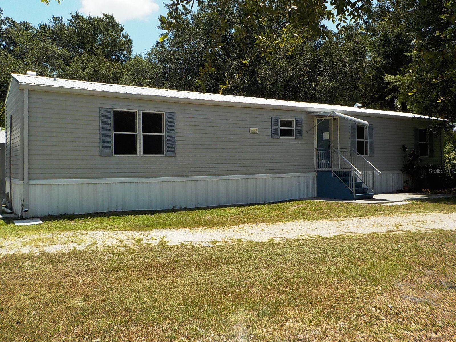 2-bedroom, 2-bath manufactured home located in the Welles Park subdivision. Built in 2004, this home offers a solid opportunity for renovation, improvement, and personalization. With a bit of updating, this home offers the opportunity to restore its original charm and make it your own.
In addition to the main home, the property features a detached outbuilding with a sink and bathroom. Seller makes no representation regarding permitted use, conforming status, occupancy approval, zoning, code compliance, square footage, utilities, or any allowable use of this structure. The buyer and the buyer’s agent must independently verify all information with the appropriate authorities. Property available for Owner Occupants, Nonprofits, and Government Agencies only FIRST! All information is deemed reliable but not guaranteed. This is a HUD-owned property and is being sold as is. FHA Case # 093-621927 IN (Insured) 203K  Eligible, subject to an FHA appraisal. FHA $100 Down Eligible. Sold AS IS. See docs for disclosure. Information is not guaranteed. Equal Housing Opportunity. The buyer pays all transfer fees, doc stamps, and title insurance. The buyer is responsible for utilities during inspections.